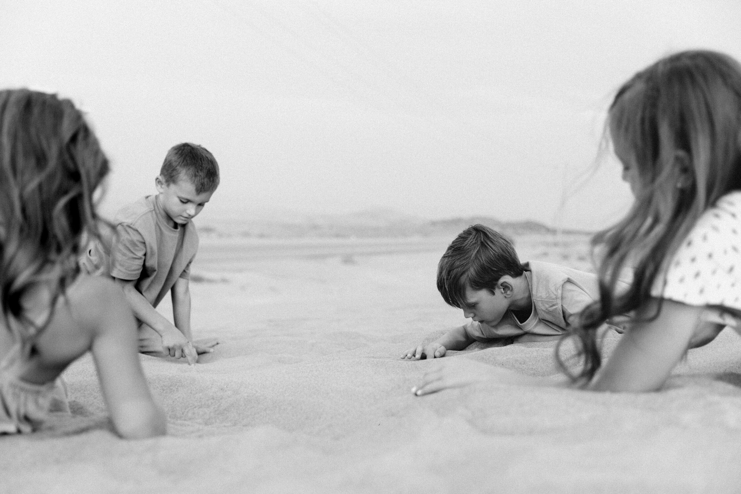 black and white kids playing in sand