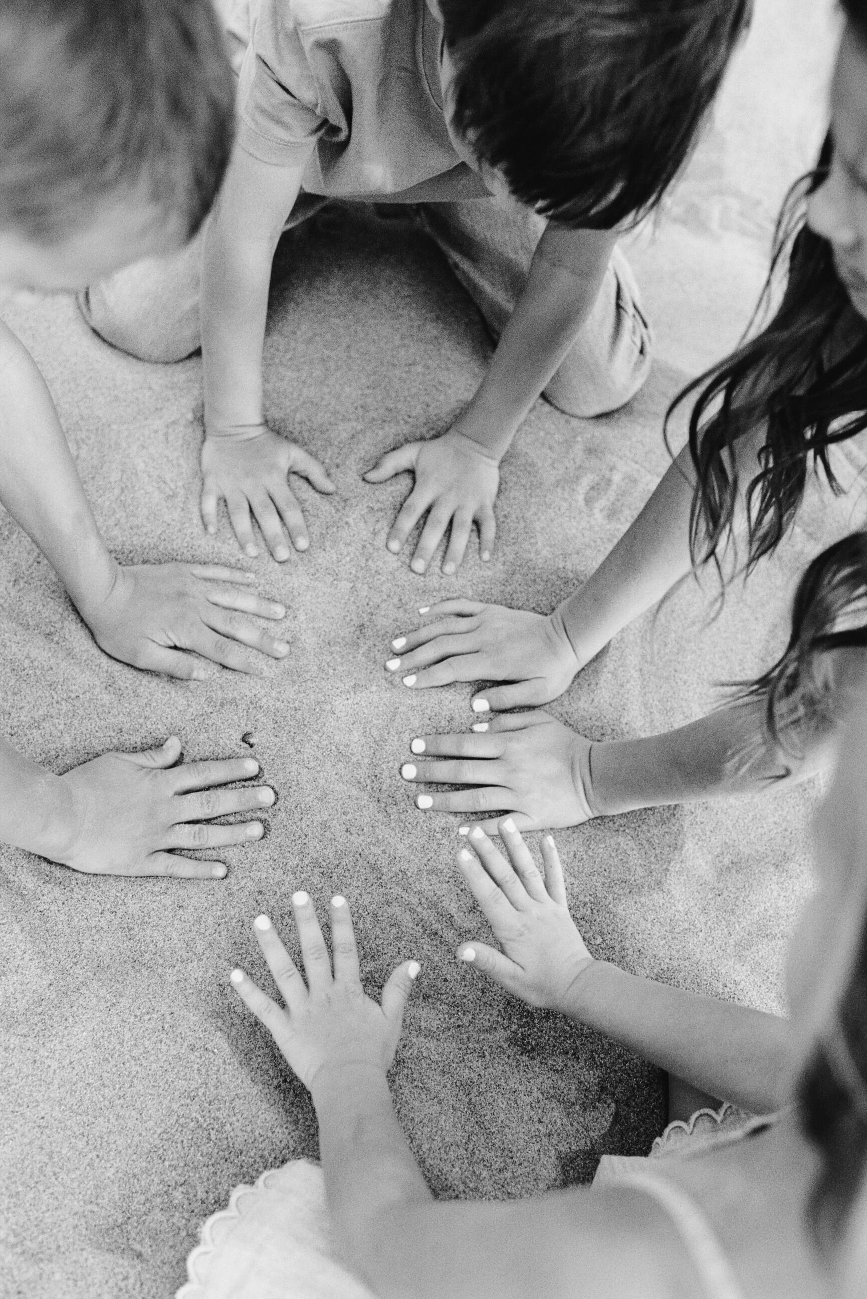 kids hands playing in sand