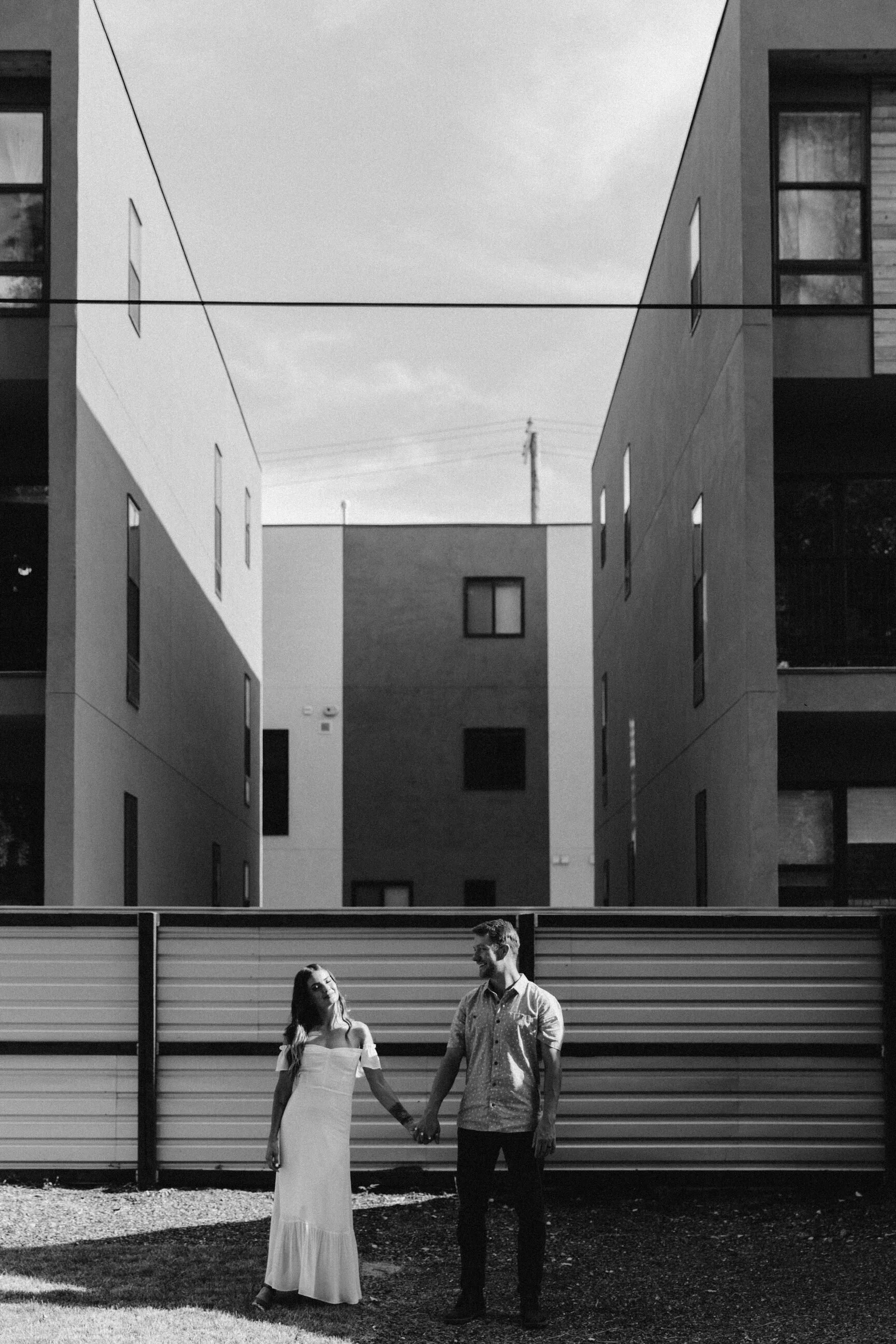 male female couple in bridal attire industrial buildings in background