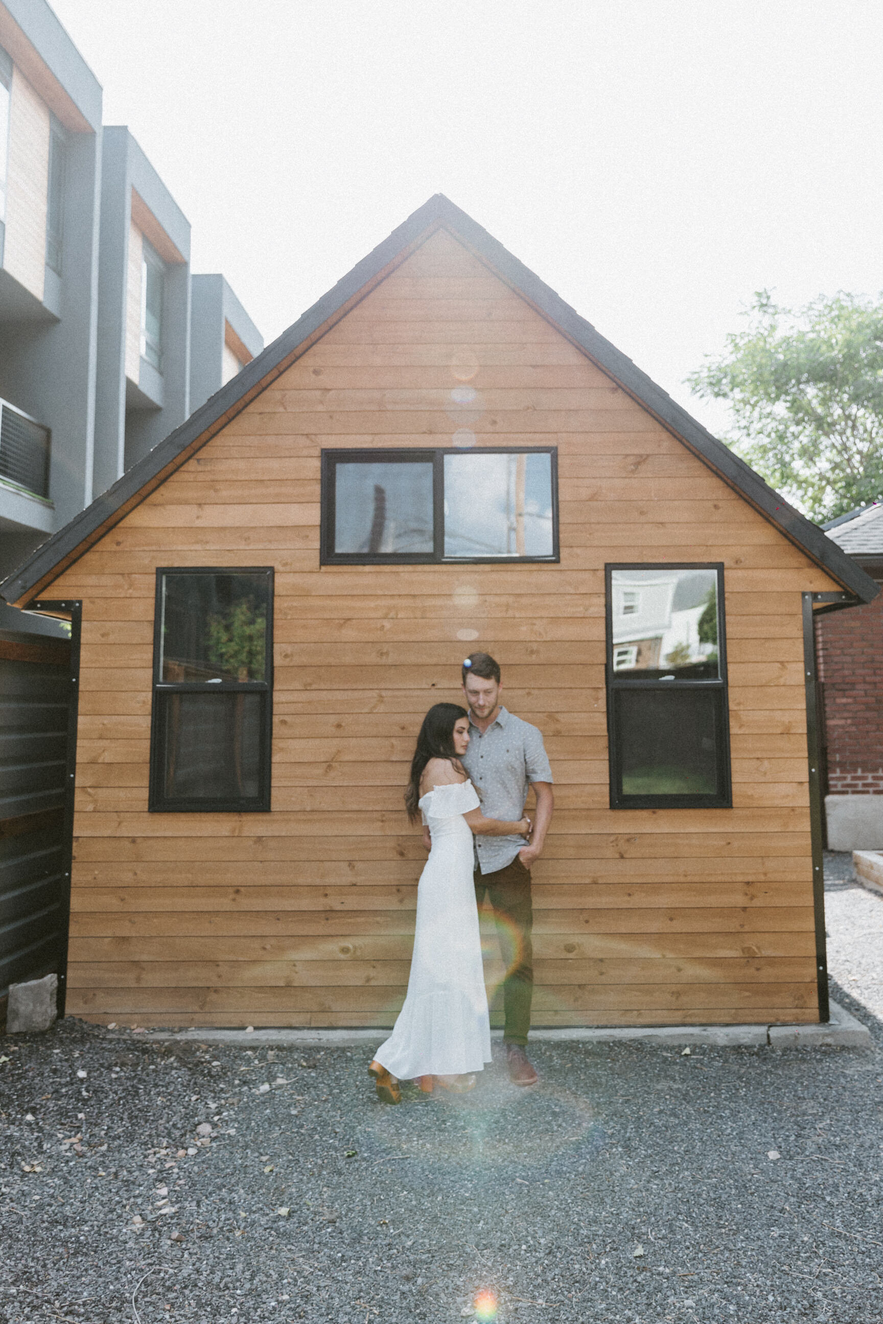 male female couple standing in bridal attire in front of shed sunlight