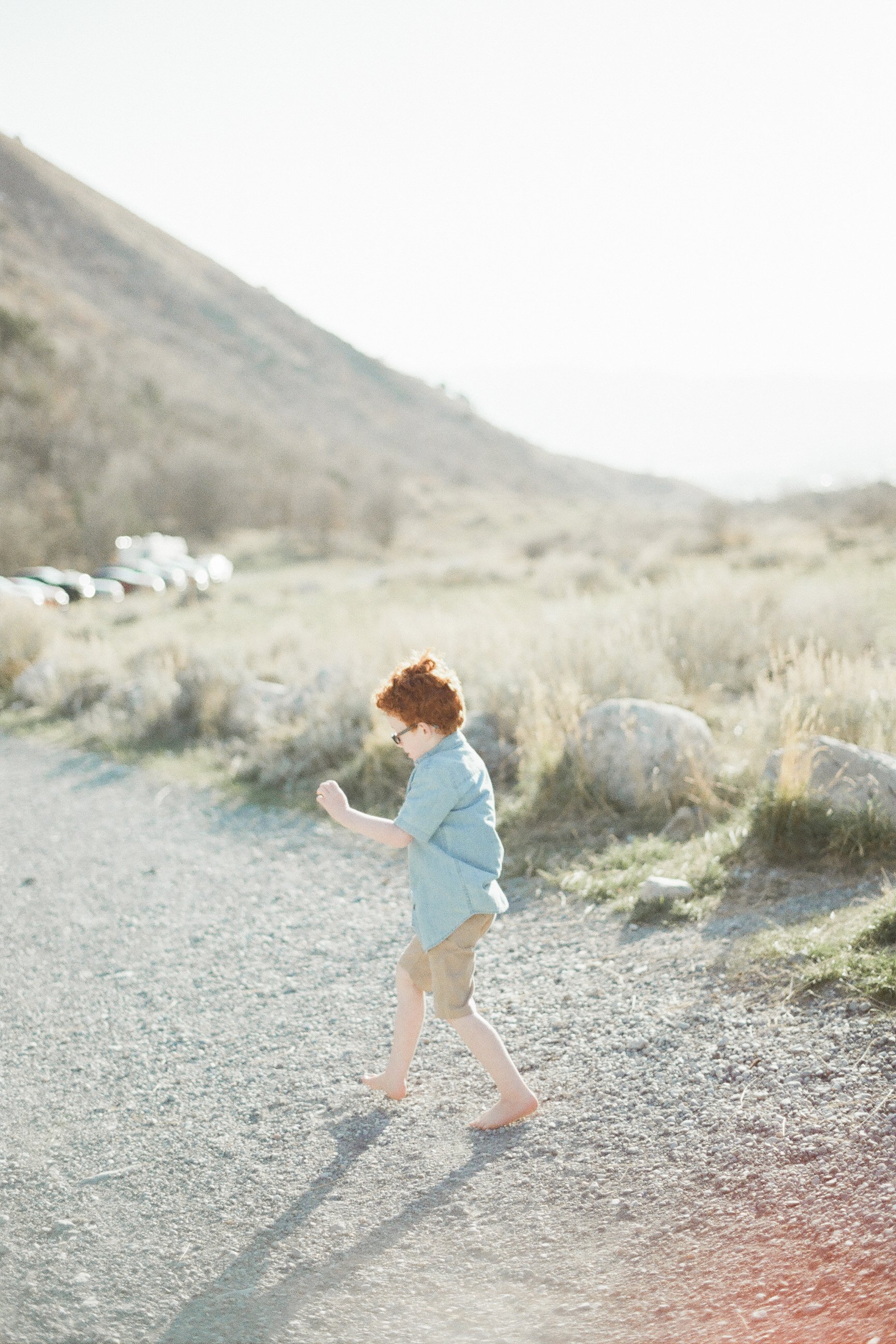 boy walking on dirt road barefoot