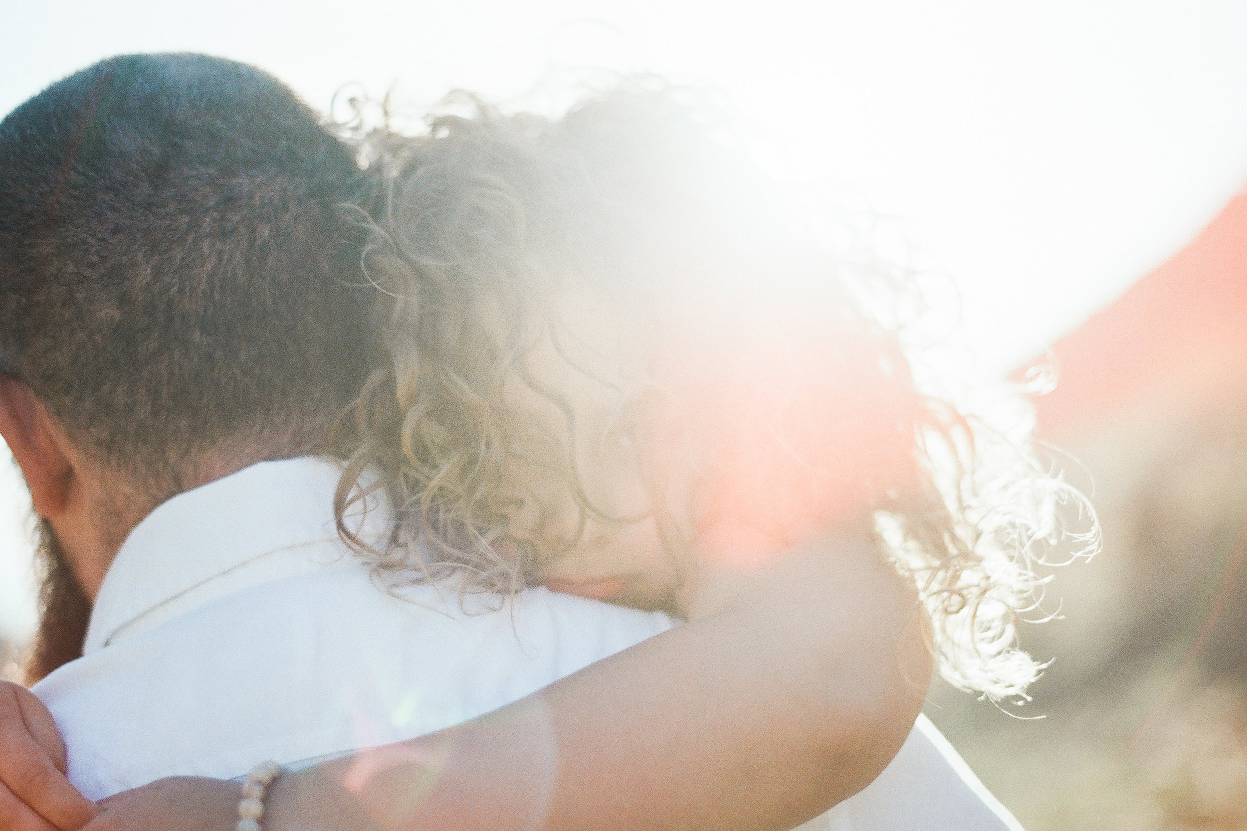curly haired girl hugging dad looking over his shoulder