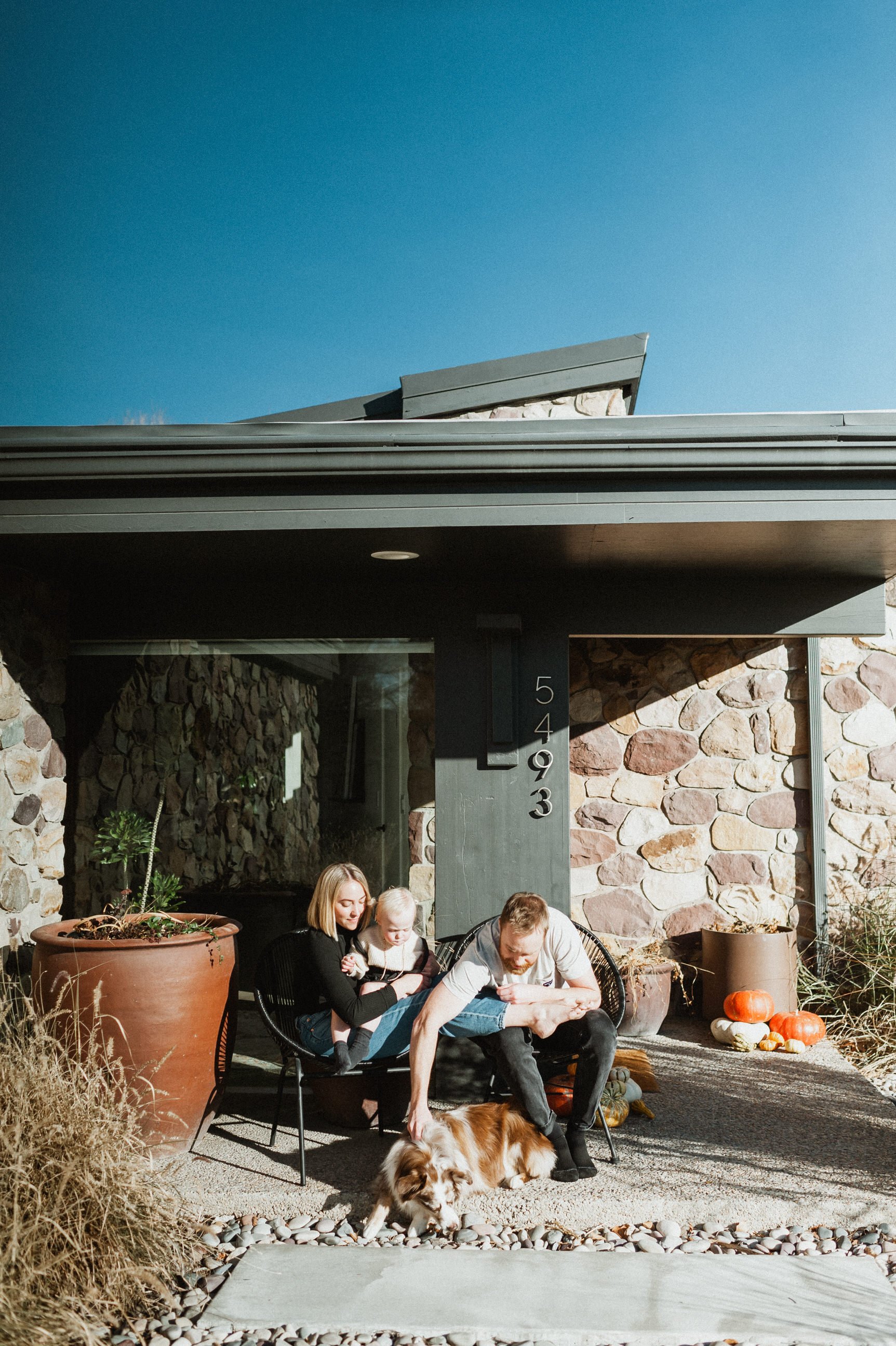 family on porch outside mid-century modern home