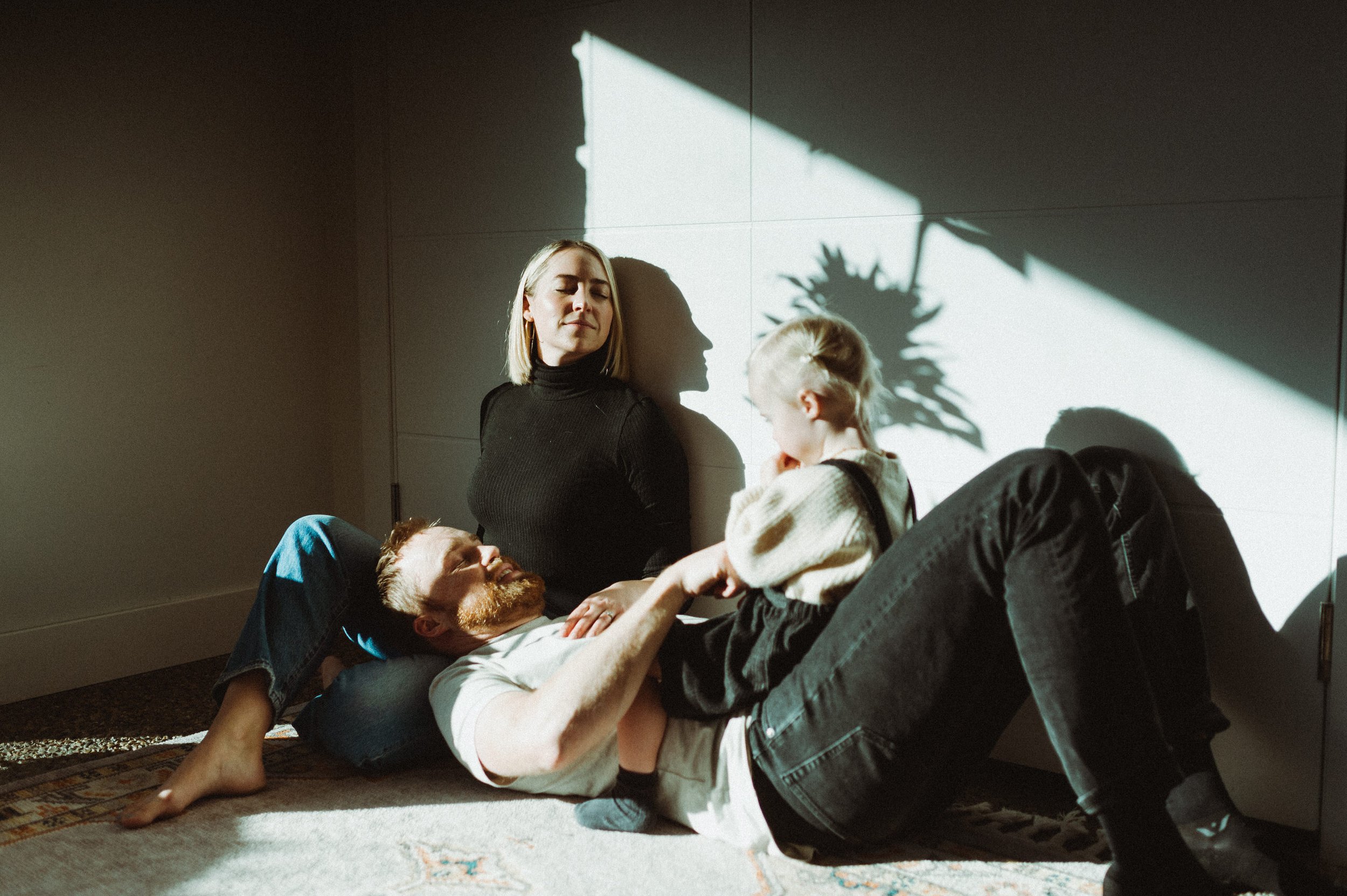 family of three sitting in mid century modern entryway at home