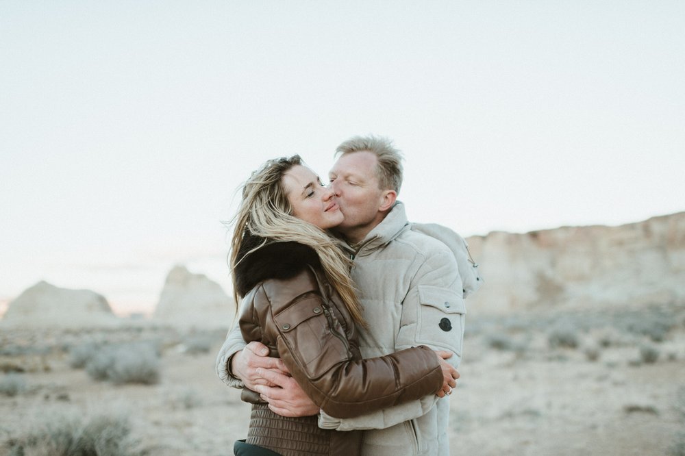 man and woman hugging faces close together eyes close desert mesa background amangiri