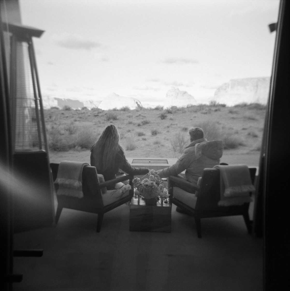 black and white film of couple sitting on veranda viewing desert sunset with mesa and desert view at amangiri resort