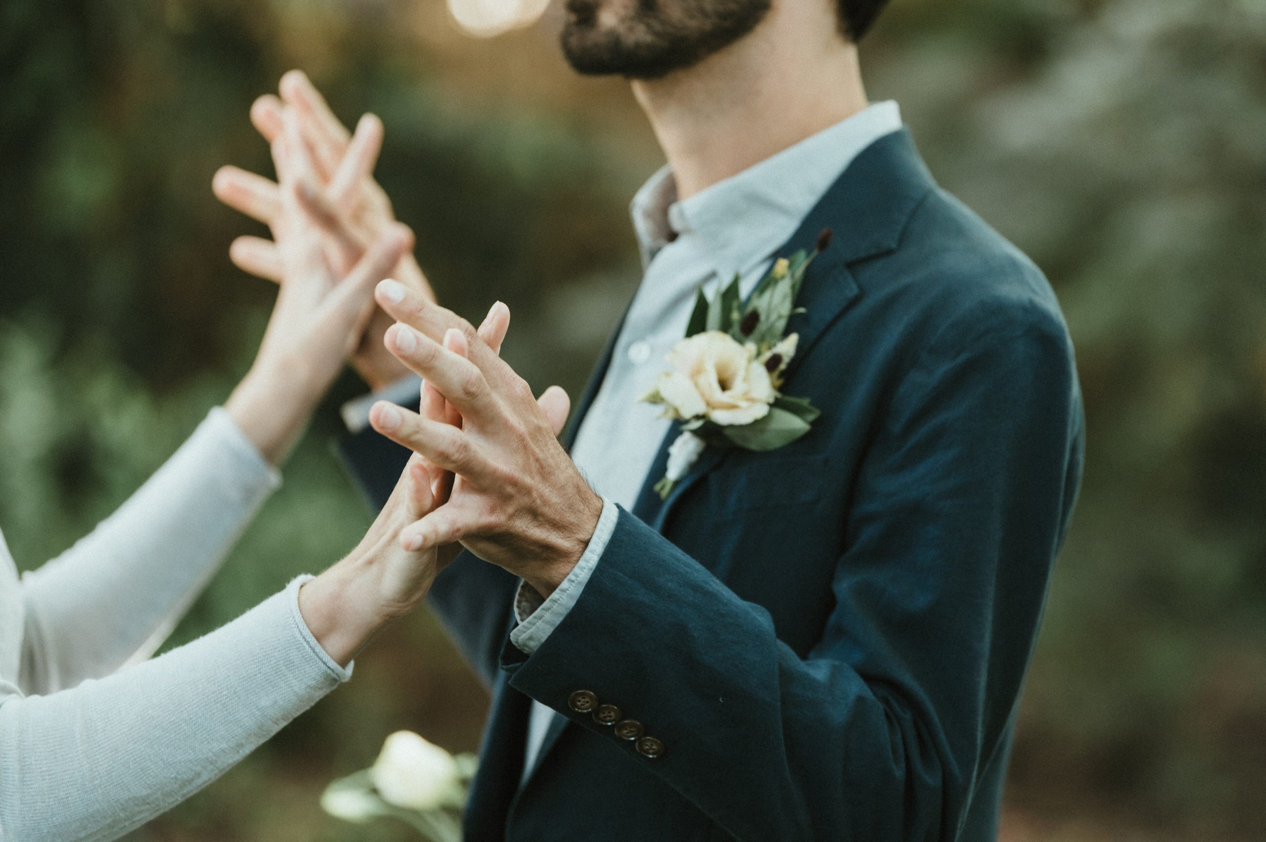 bride and groom intertwining hands close up