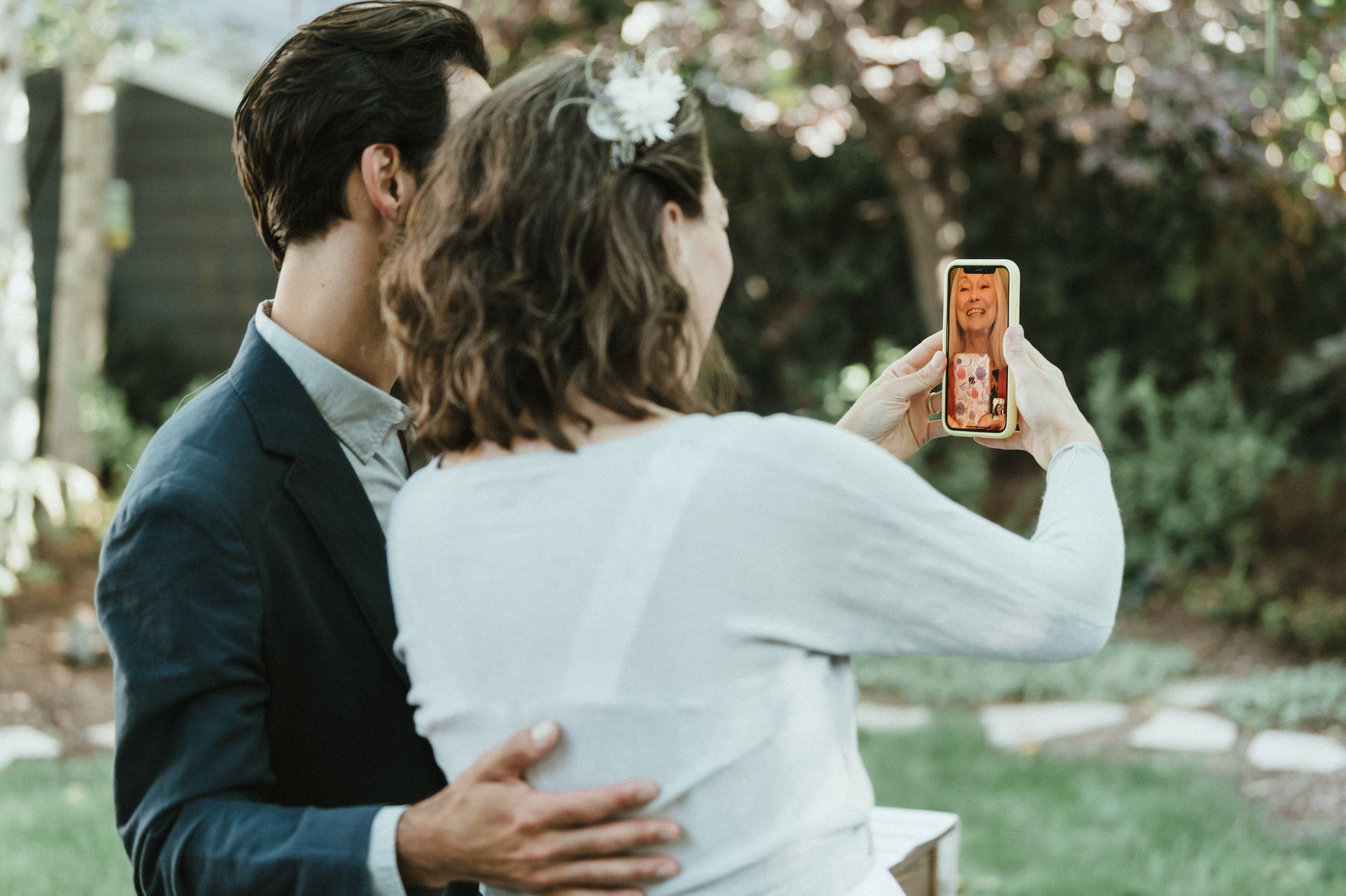 bride and groom facetiming bride mom on phone after wedding