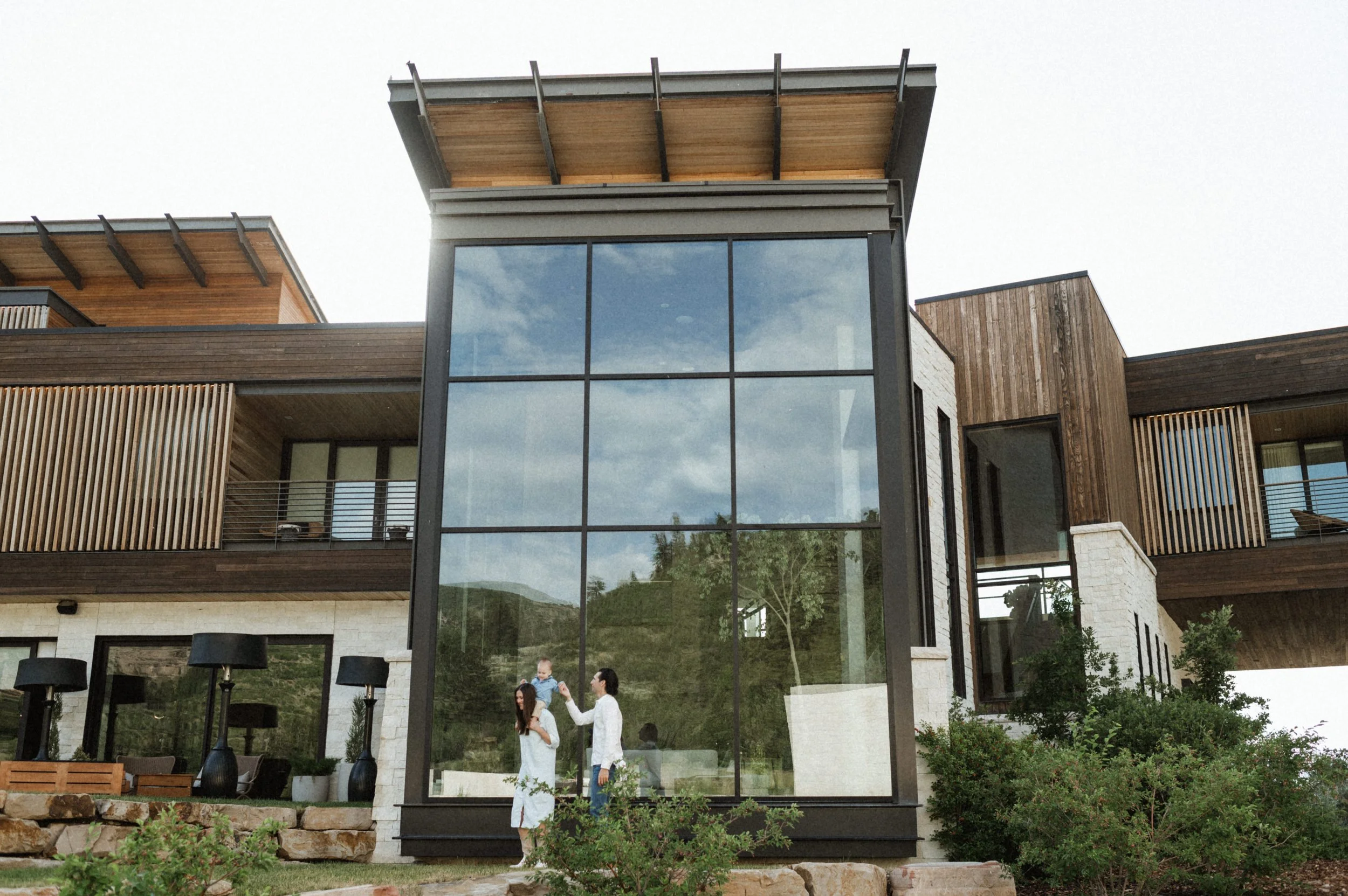 outdoor mountains family photo in front of large windows at the lodge at blue sky park city utah