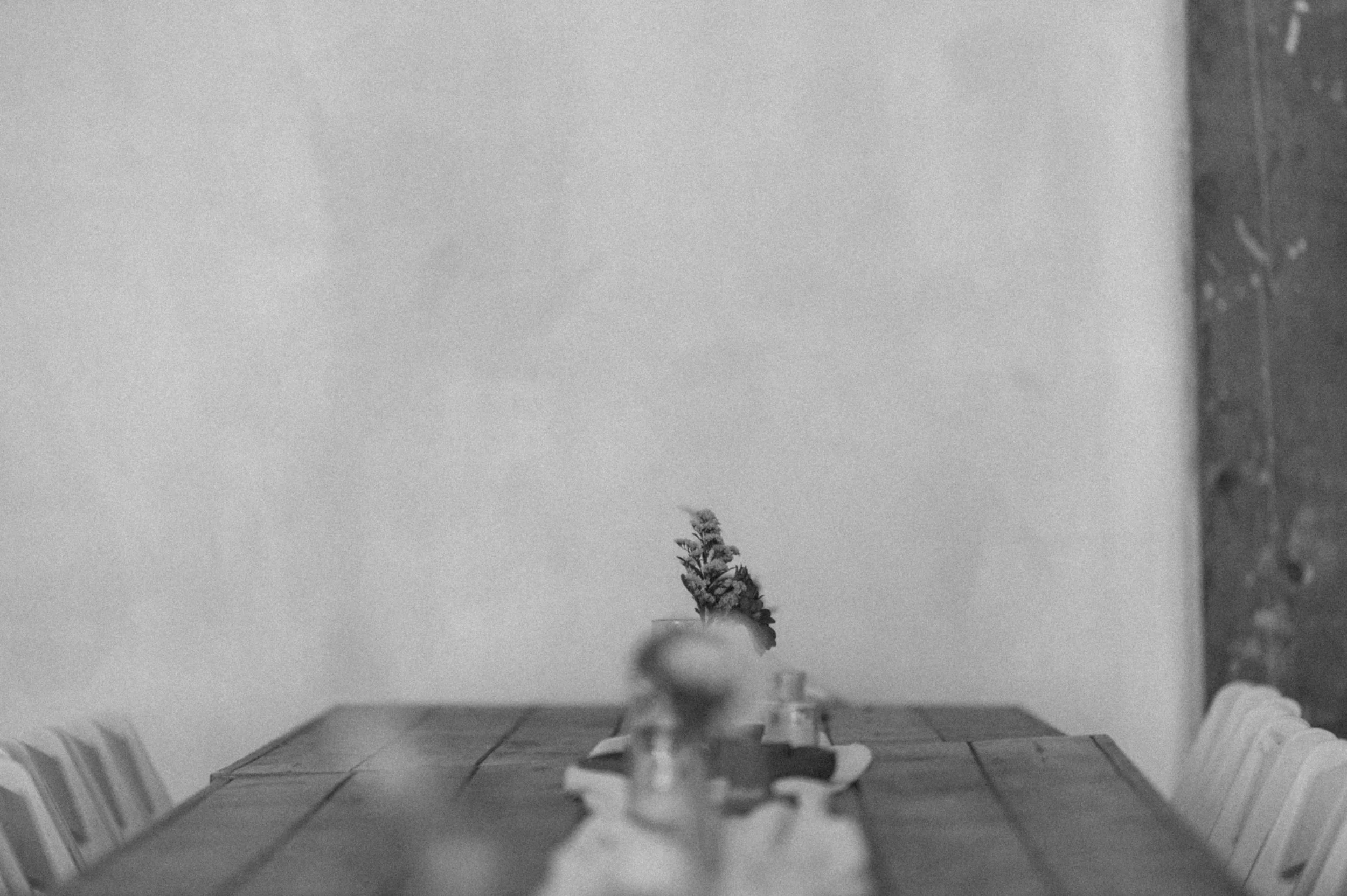 black and white image industrial modern wedding venue in utah wooden table white plaster walls