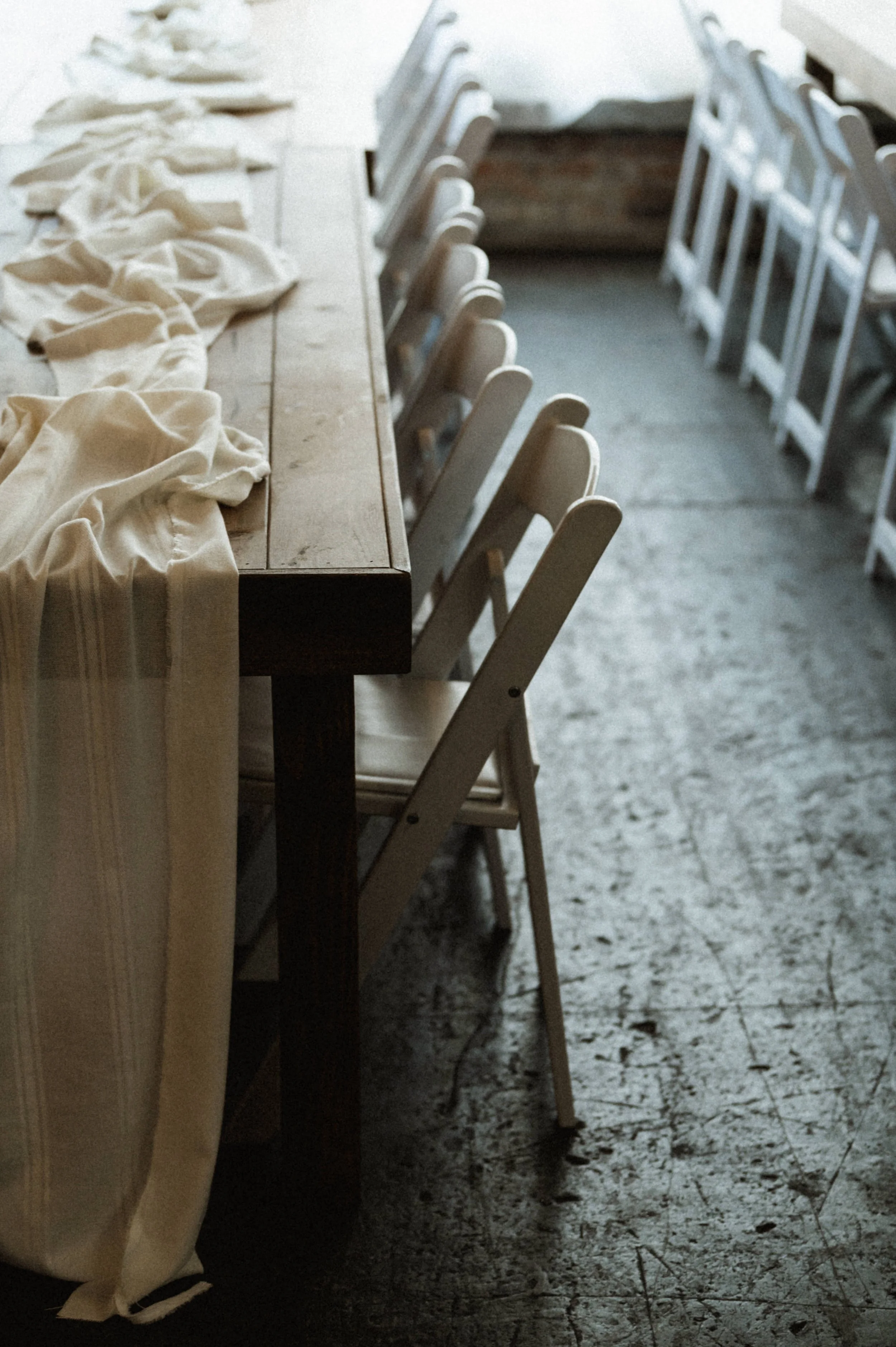 wooden table and chairs concrete floor wedding venue