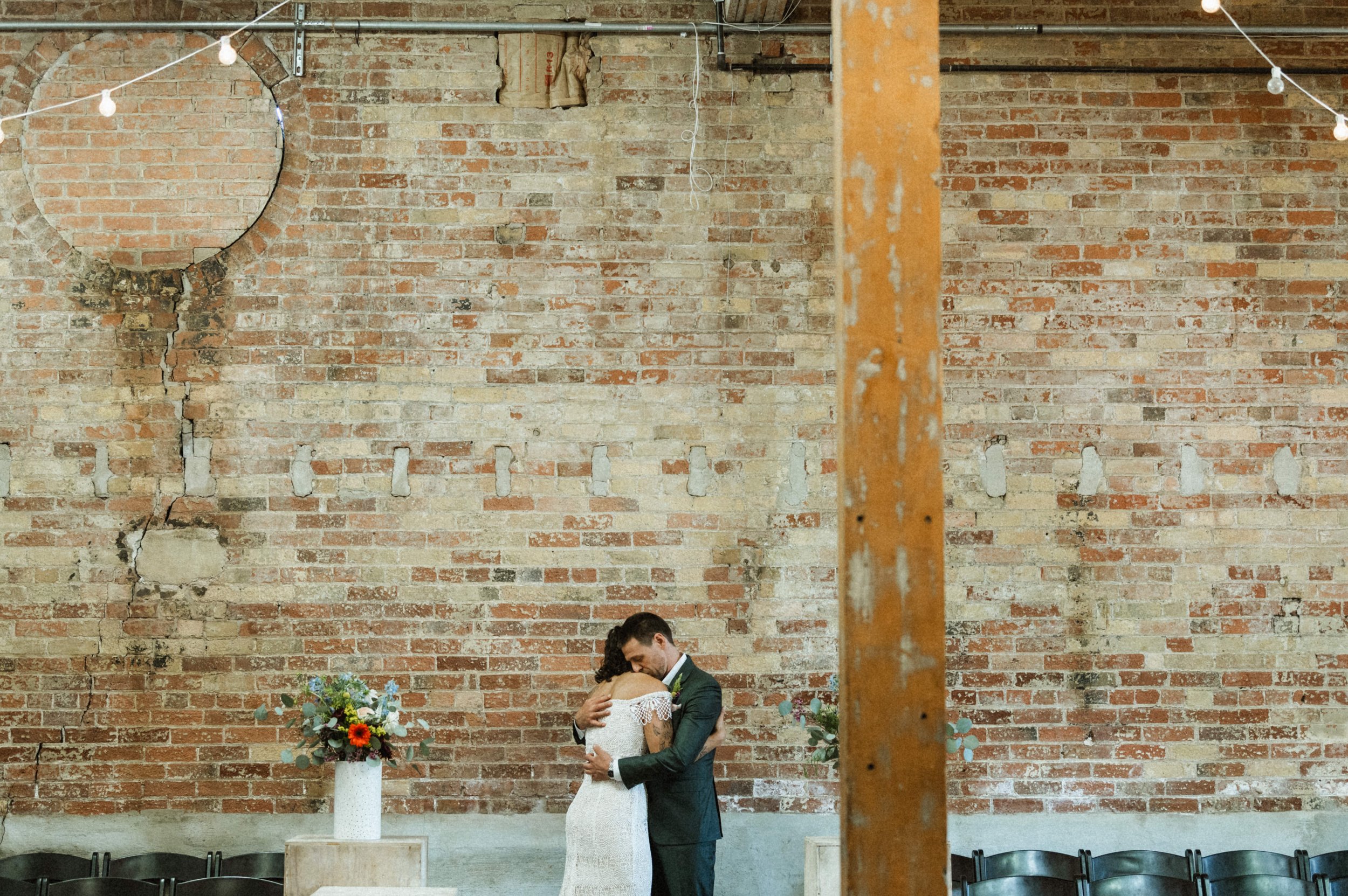 Bride and groom portrait against industrial brick backdrop at Ember, downtown Salt Lake City