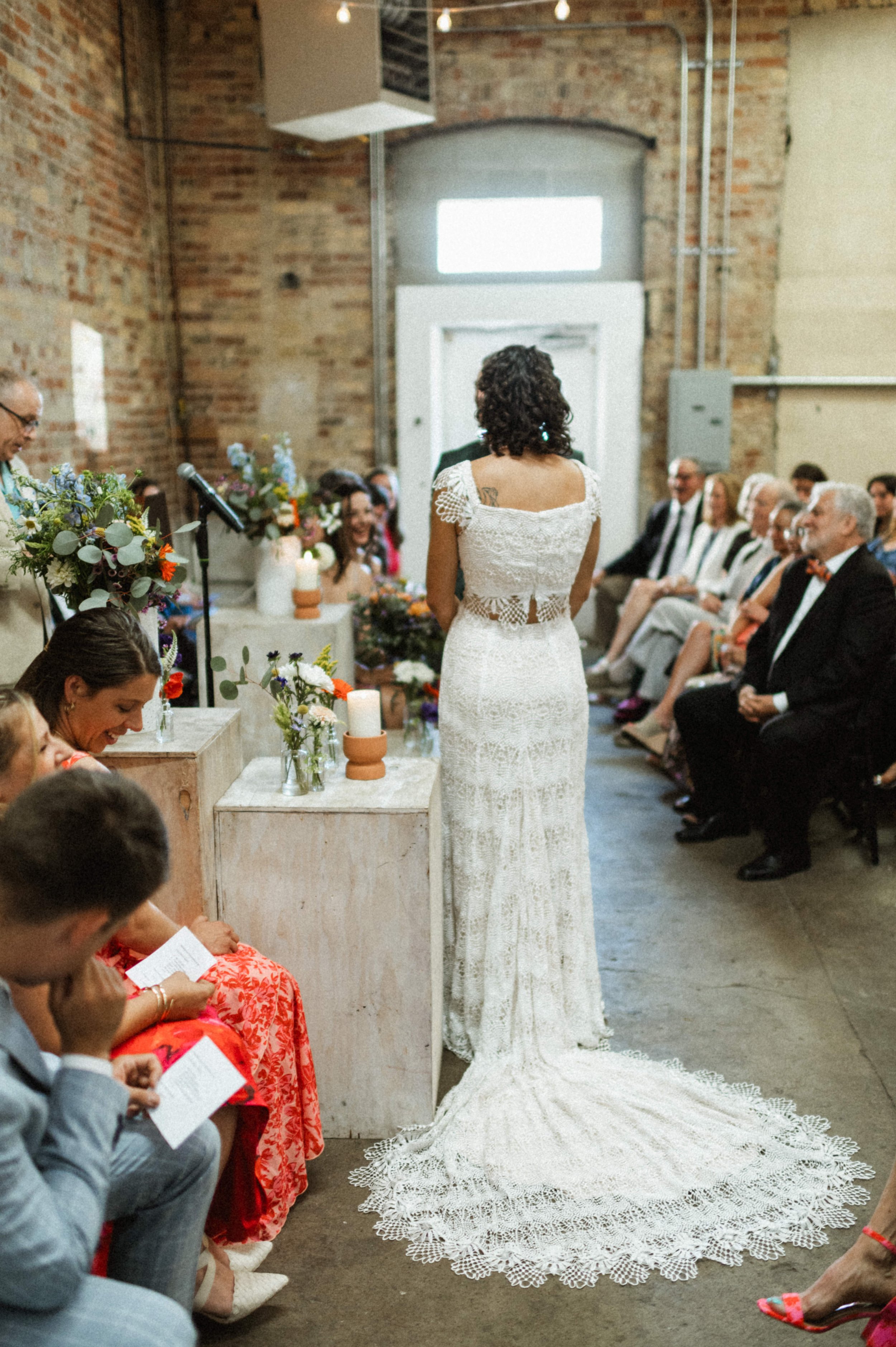 Eclectic modern wedding ceremony setup with exposed brick at Ember Studios