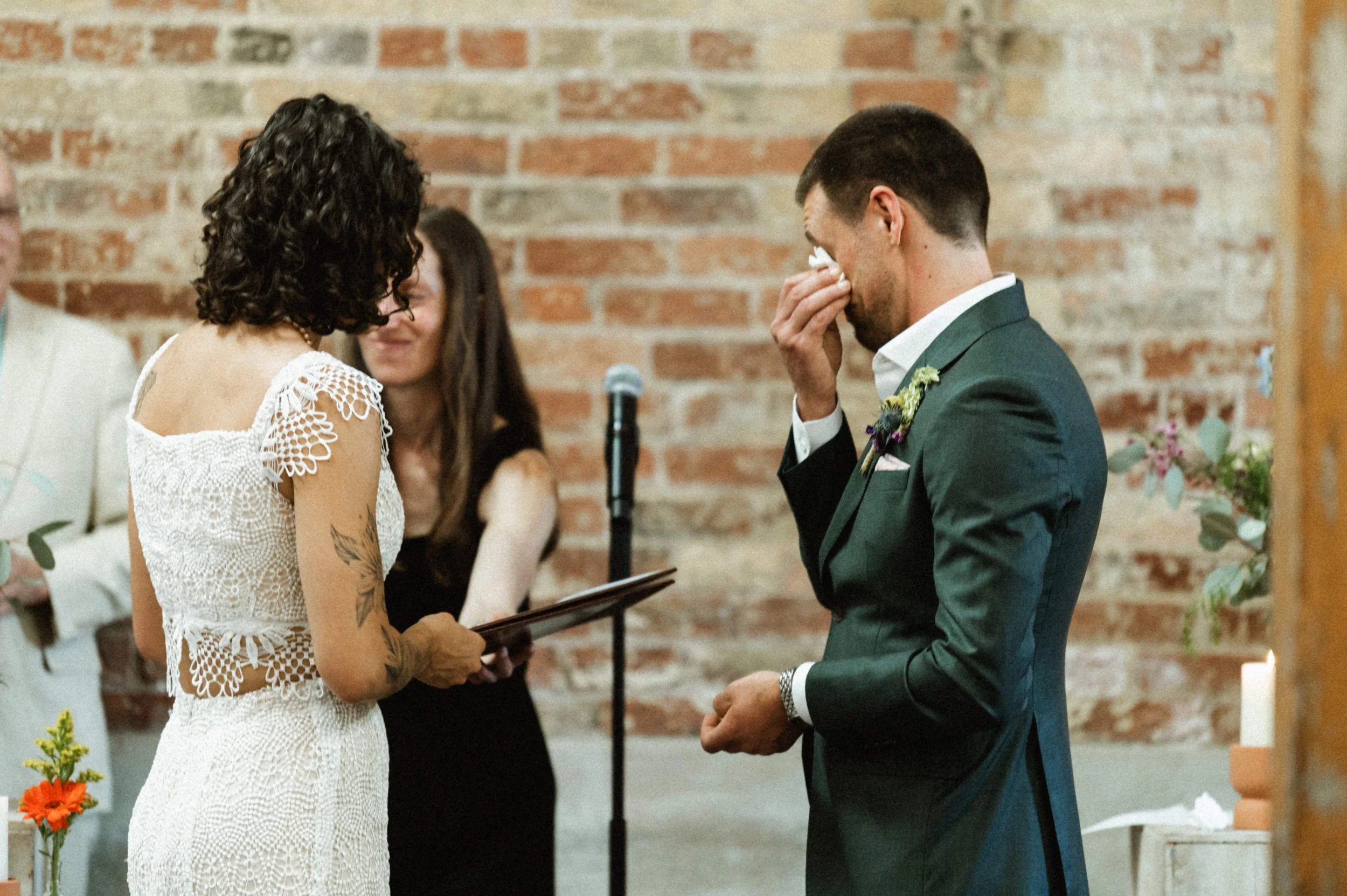 Eclectic modern wedding ceremony setup with exposed brick at Ember Studios