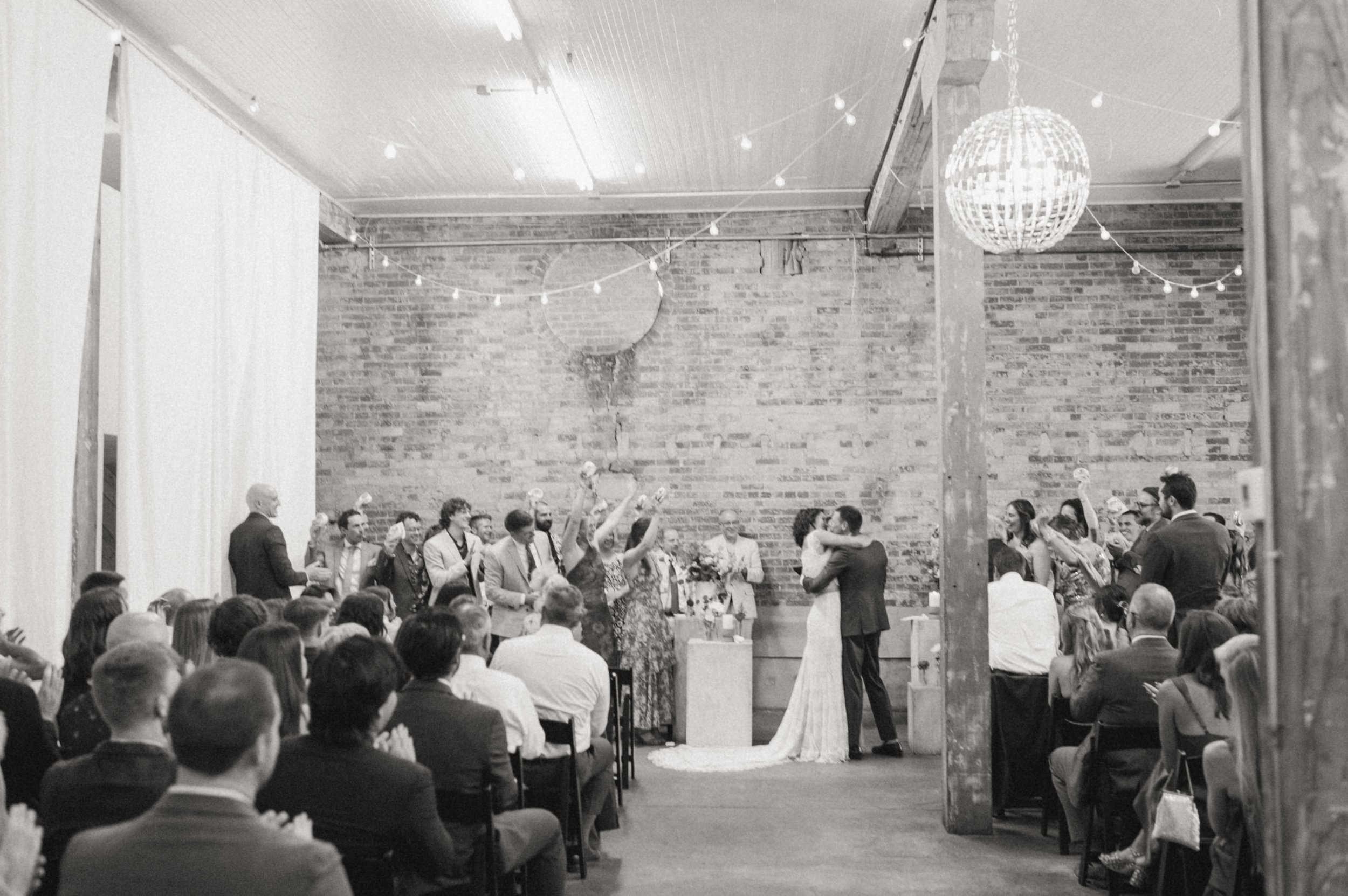 Wedding ceremony beneath vaulted industrial ceilings at Ember, Salt Lake City