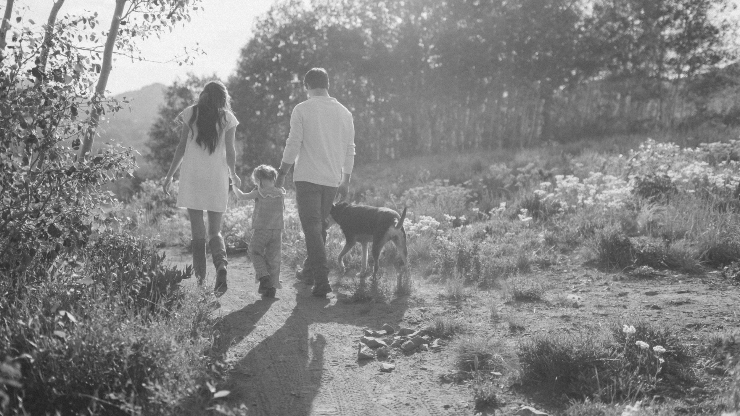 cinematic frame family of three walking through mountains