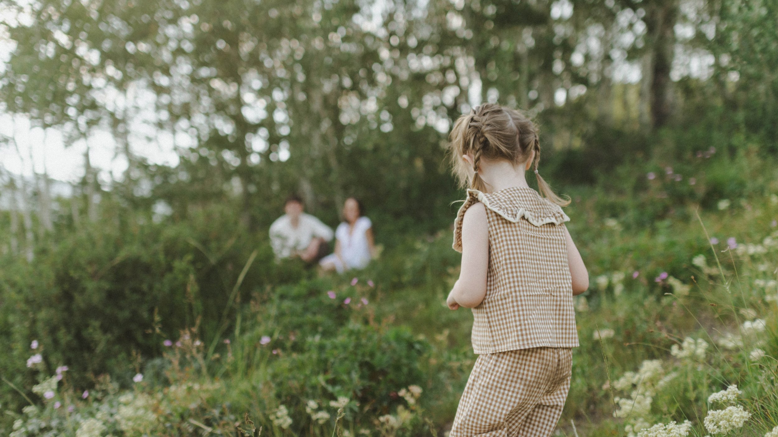 cinematic frame family of three walking through mountains