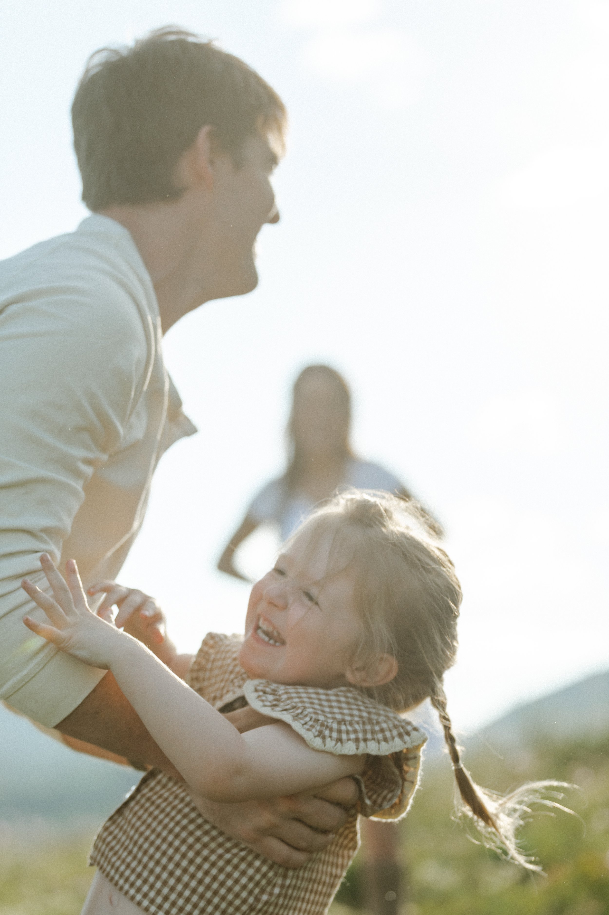 dad lifting up toddler while she is laughing