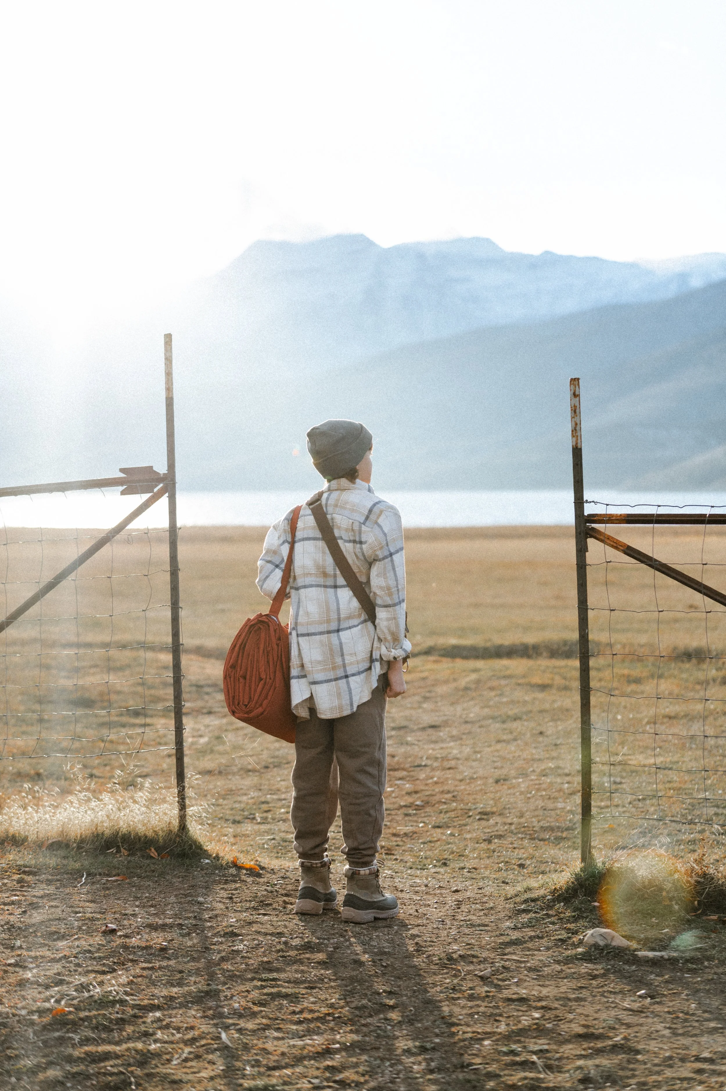 Small business product photographer capturing lifestyle shot of picnic blanket bag at golden hour by mountain lake