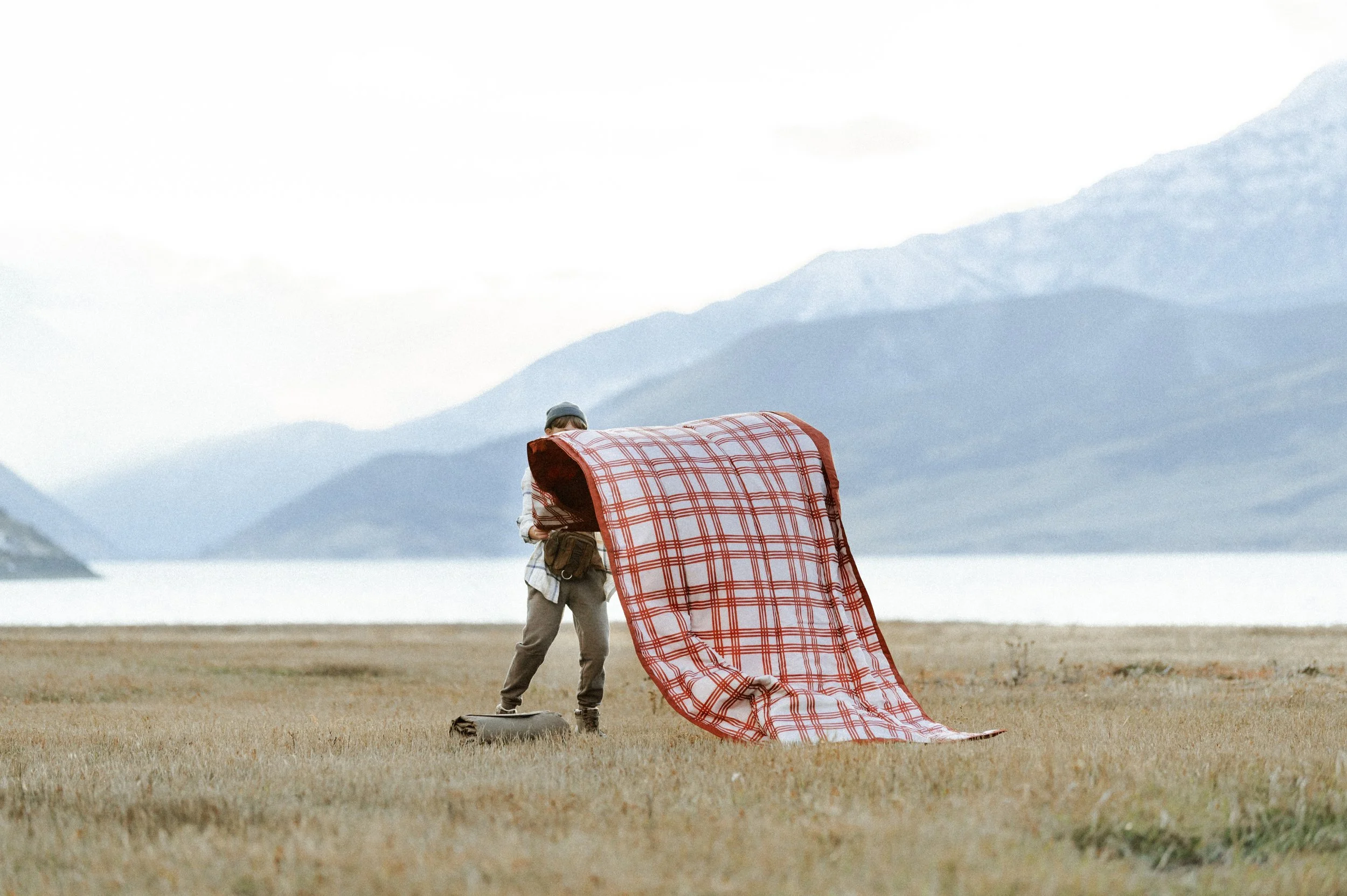 Picnic blanket flying in the wind during outdoor lifestyle product photography shoot near mountains