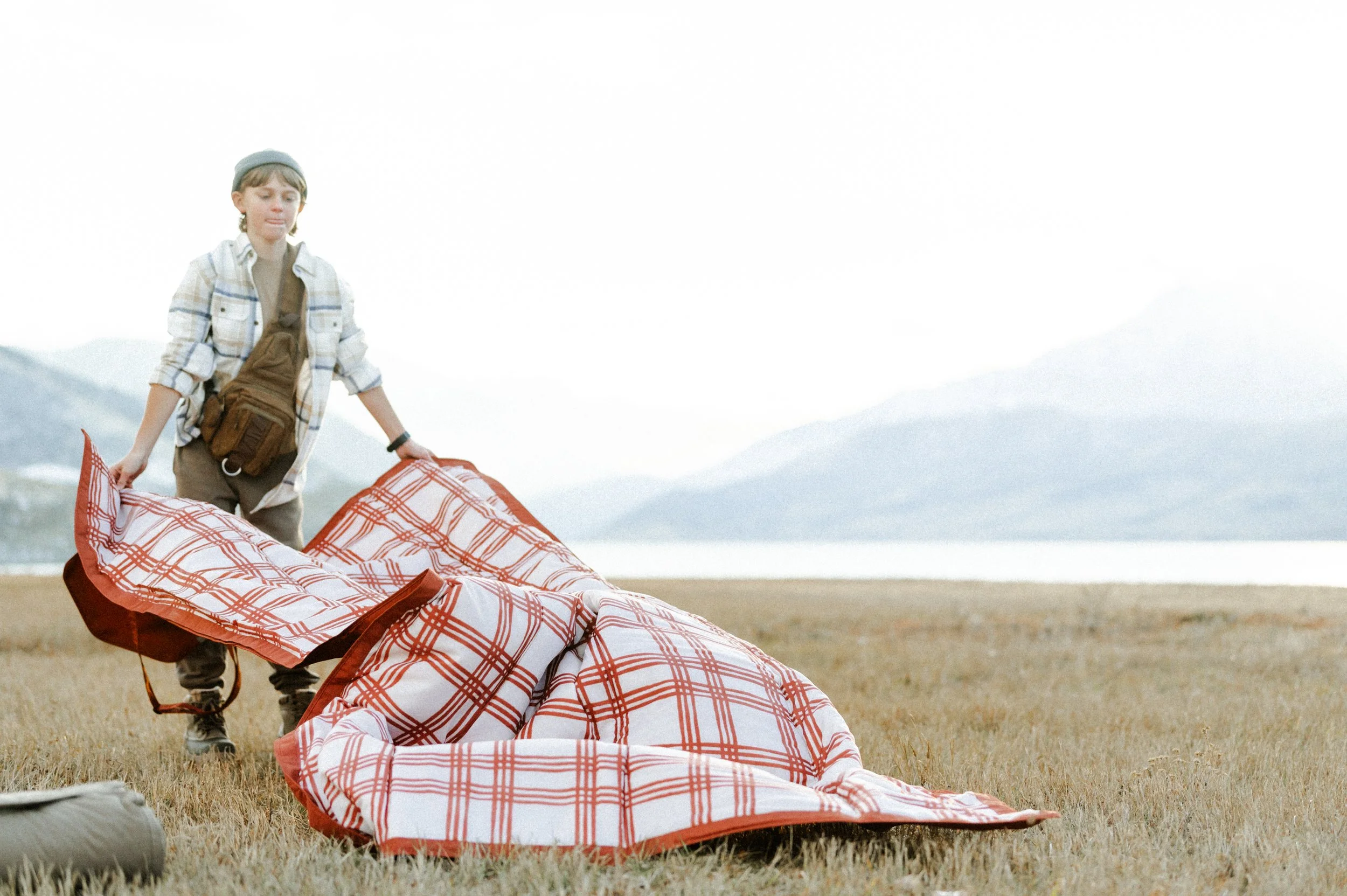 Picnic blanket flying in the wind during outdoor lifestyle product photography shoot near mountains