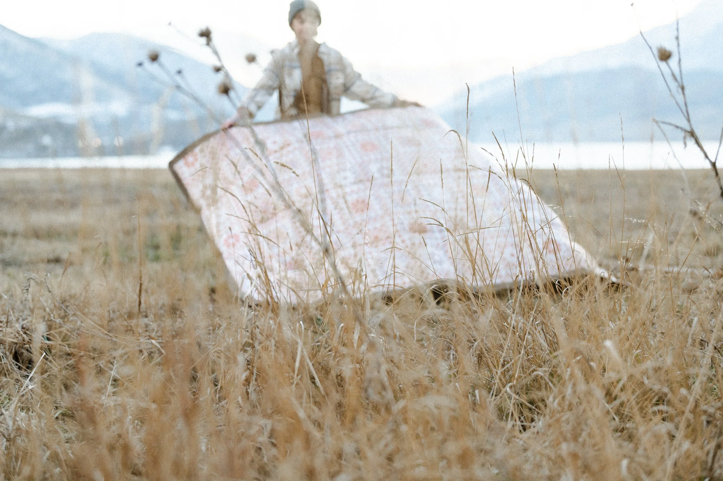 Motion blur lifestyle photo of picnic blanket laid out in field, product photographer near me style