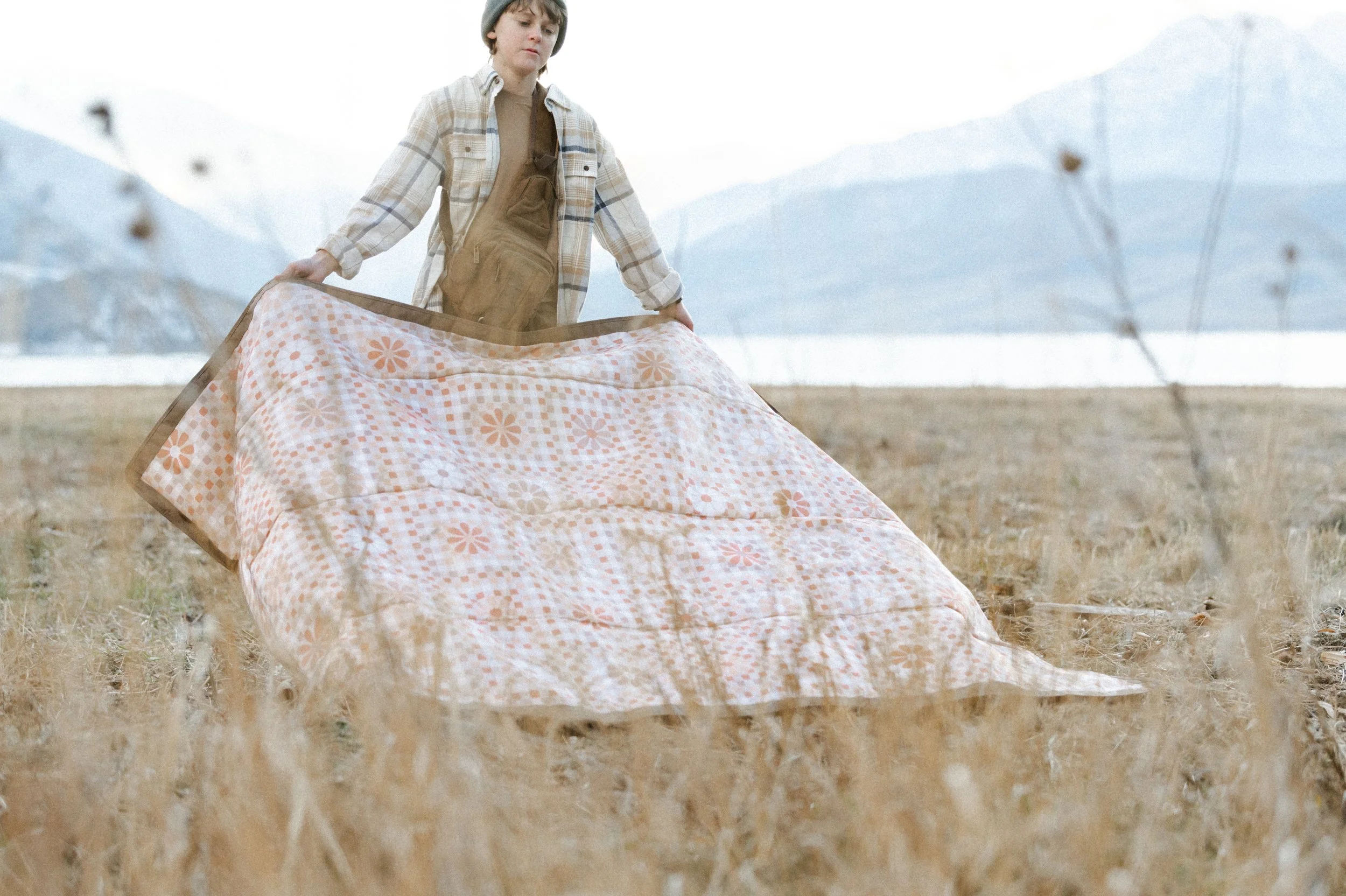 Picnic blanket flying in the wind during outdoor lifestyle product photography shoot near mountains