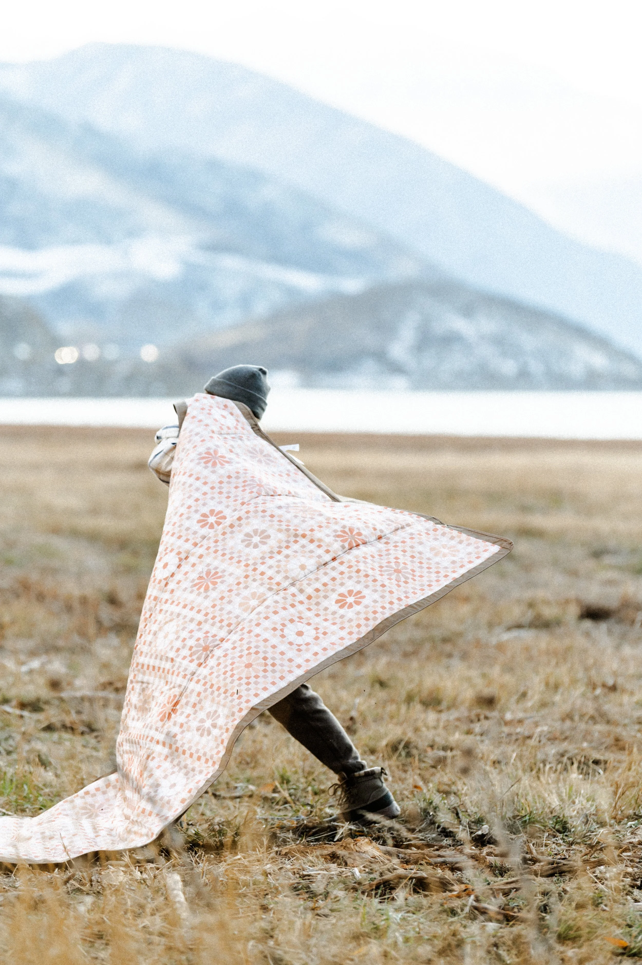 Picnic blanket flying in the wind during outdoor lifestyle product photography shoot near mountains