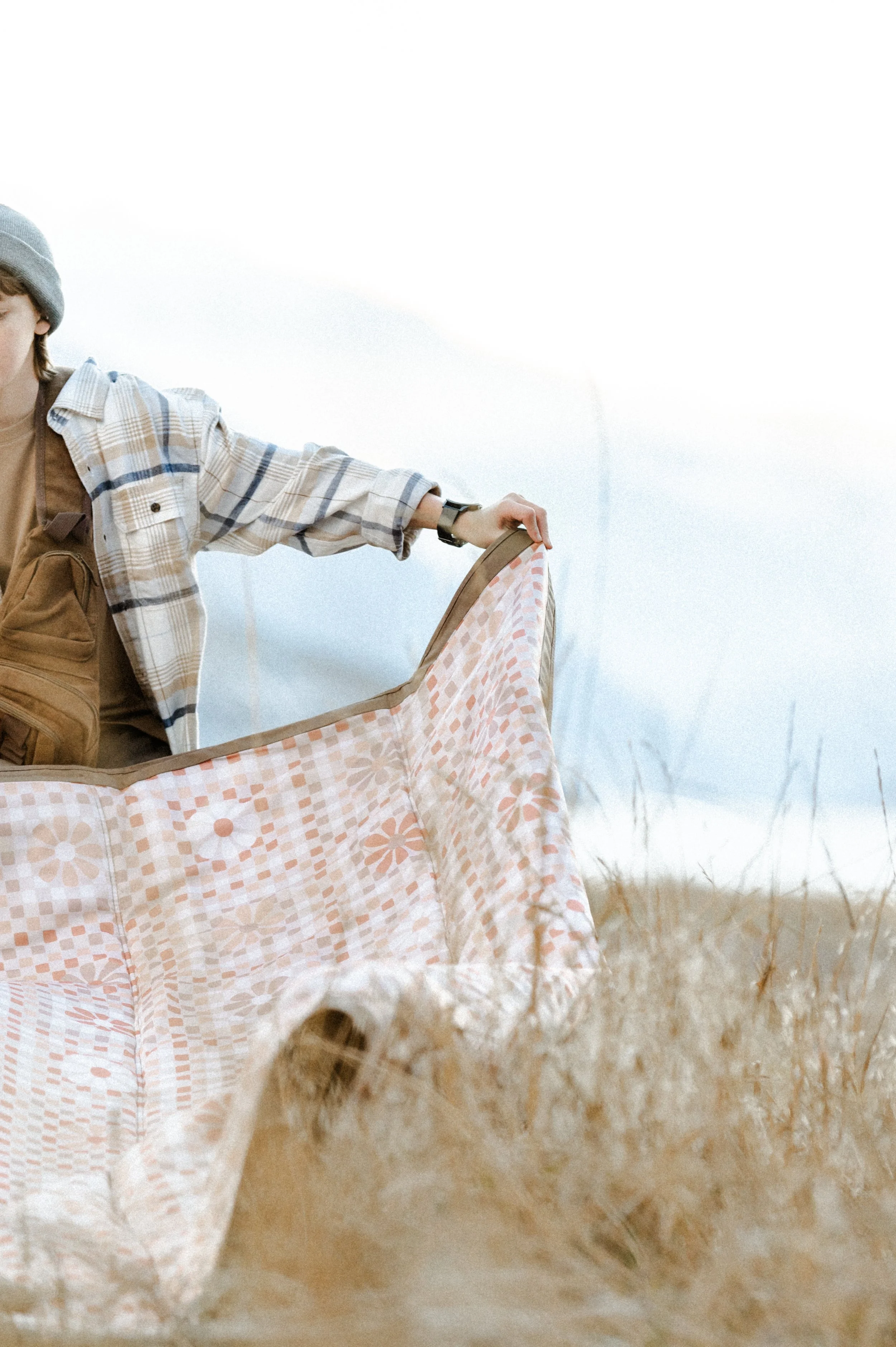 Picnic blanket flying in the wind during outdoor lifestyle product photography shoot near mountains