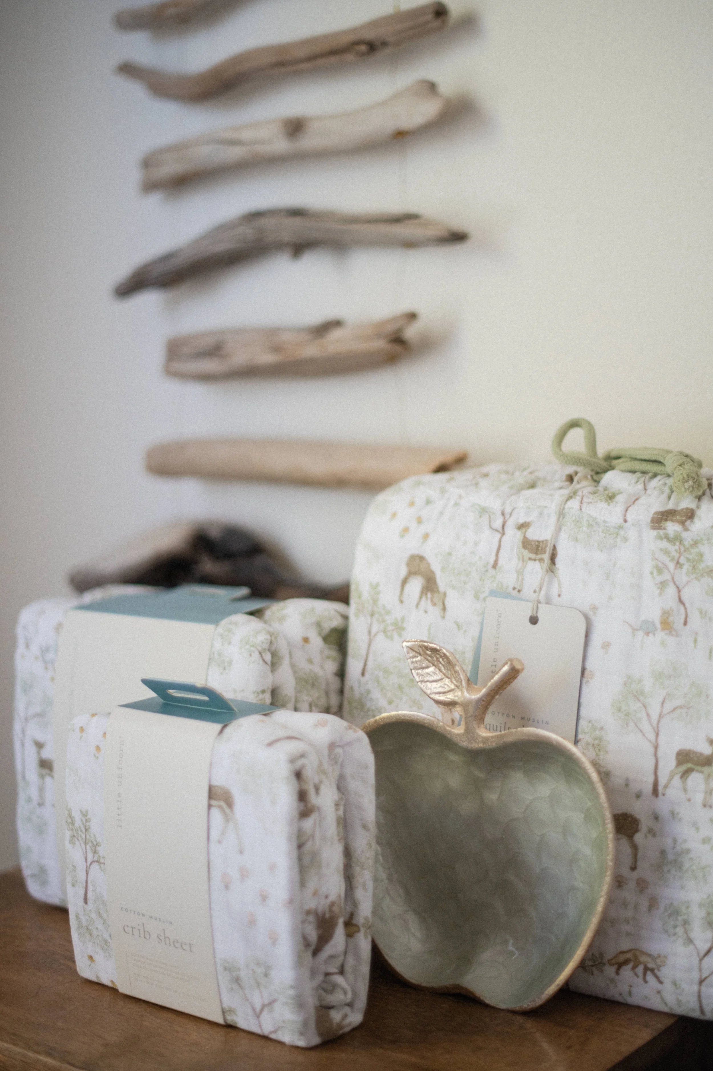 Professional product photography of Little Unicorn muslin swaddle packaging styled on shelf
