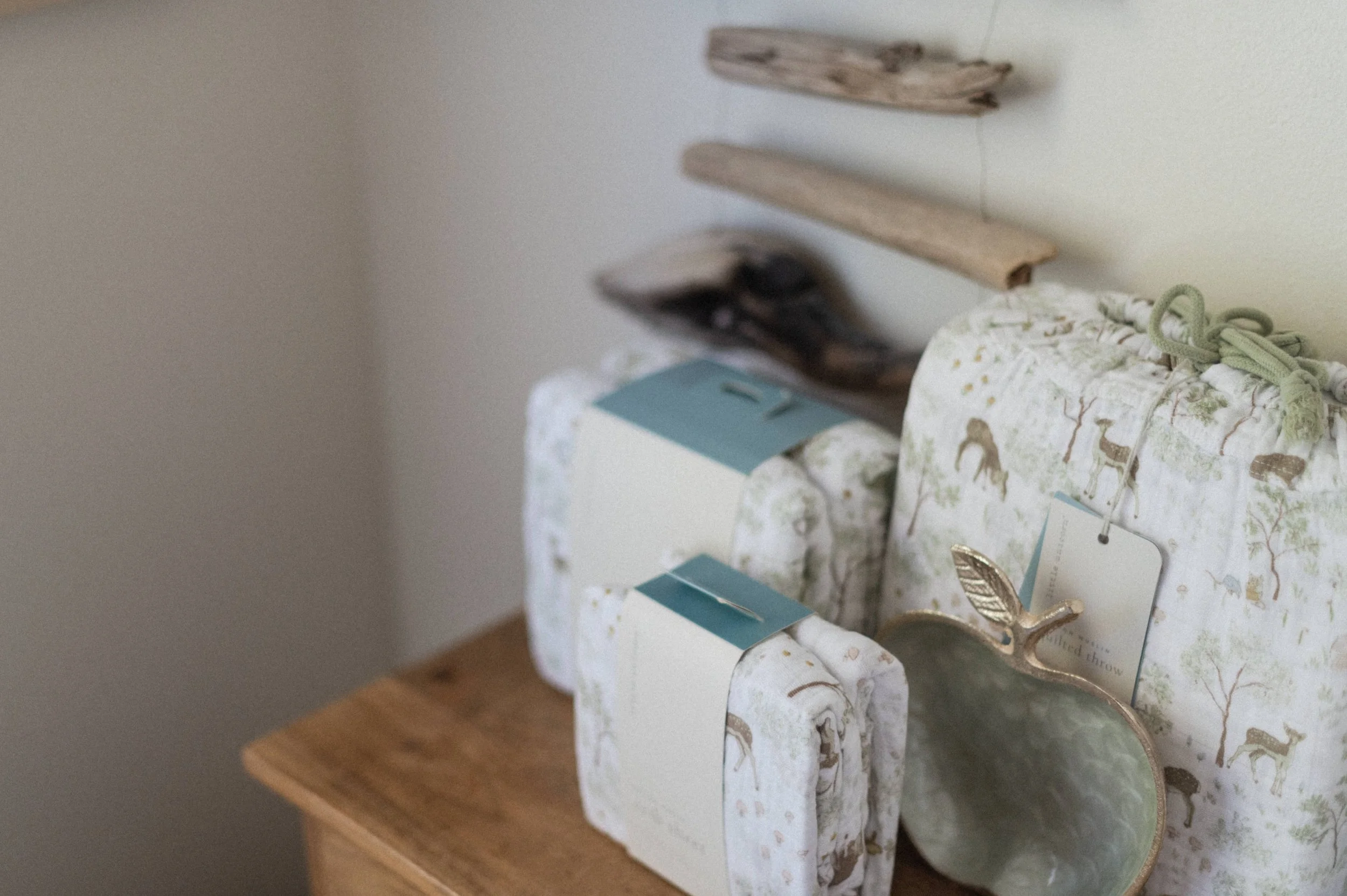 Professional product photography of Little Unicorn muslin swaddle packaging styled on shelf