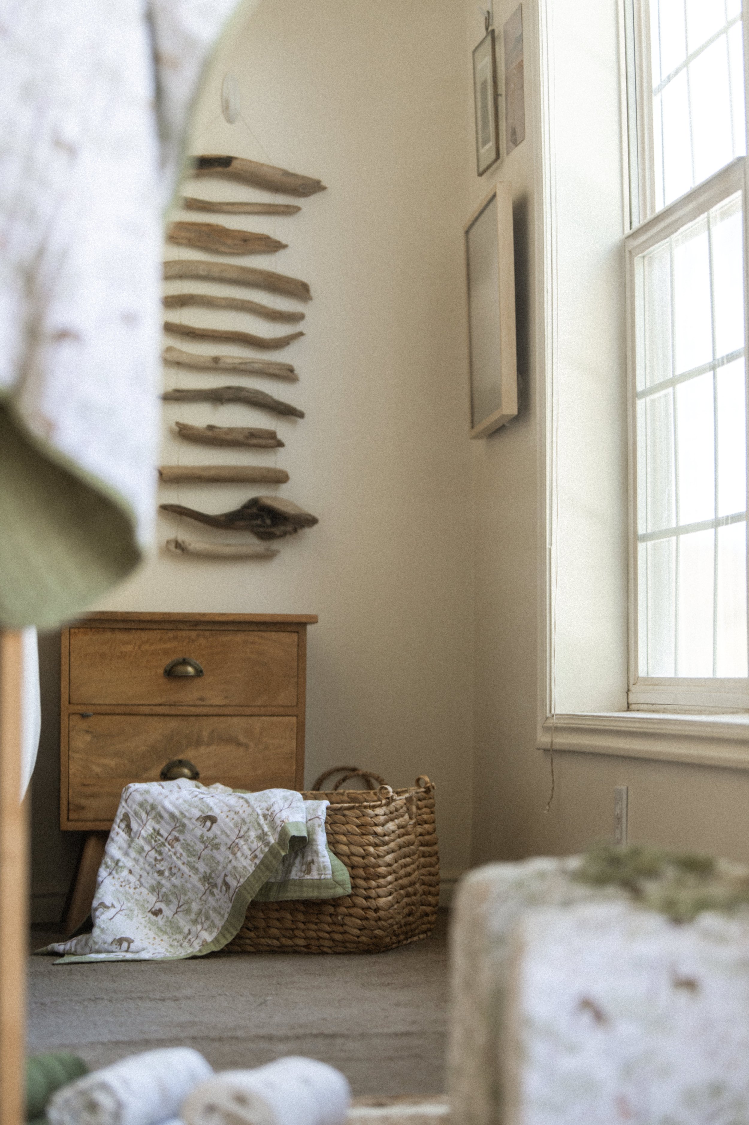 Lifestyle product photography of organic cotton quilt in woven basket, boho nursery styling