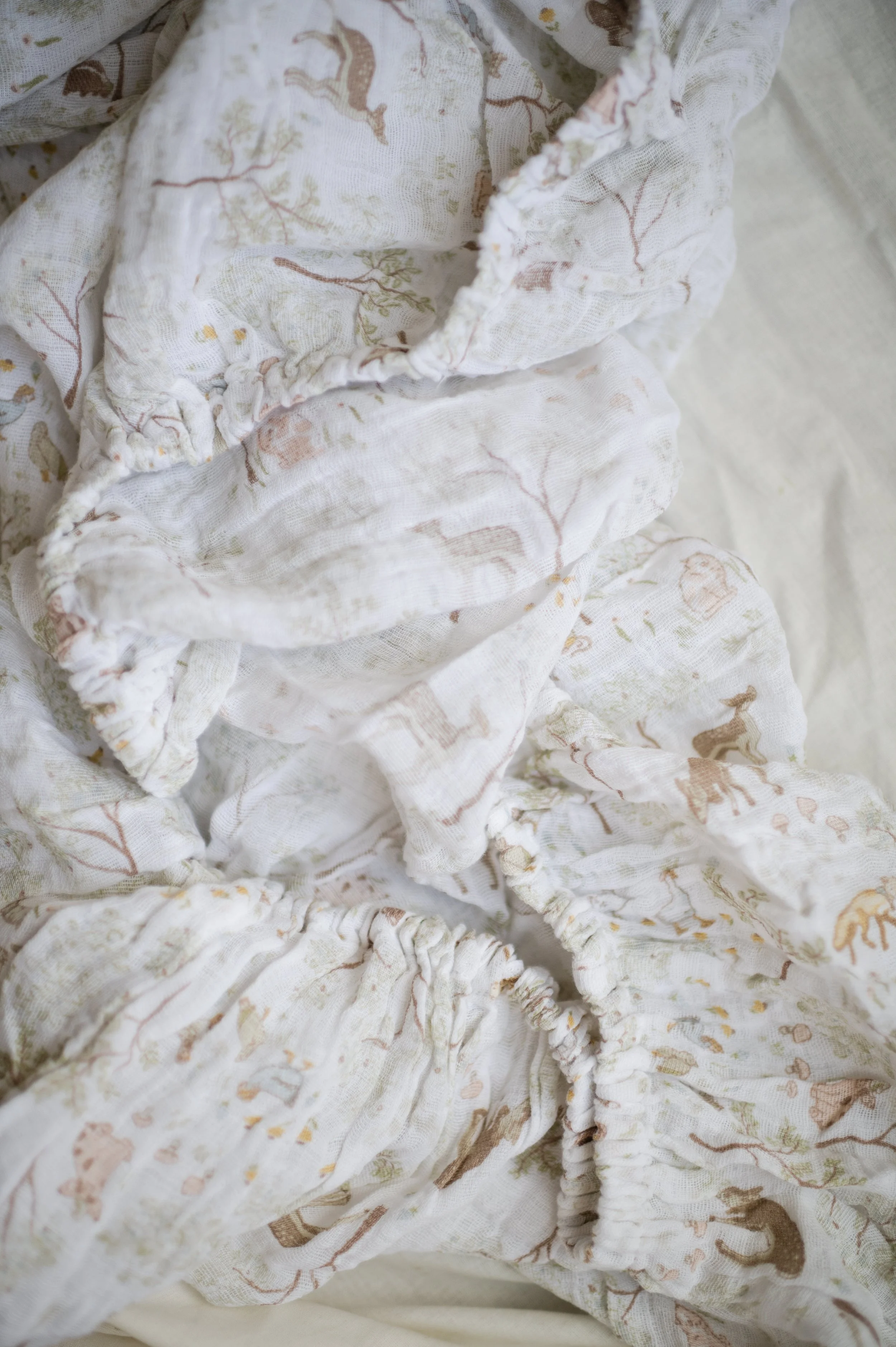 Styled flat lay of organic muslin crib sheet