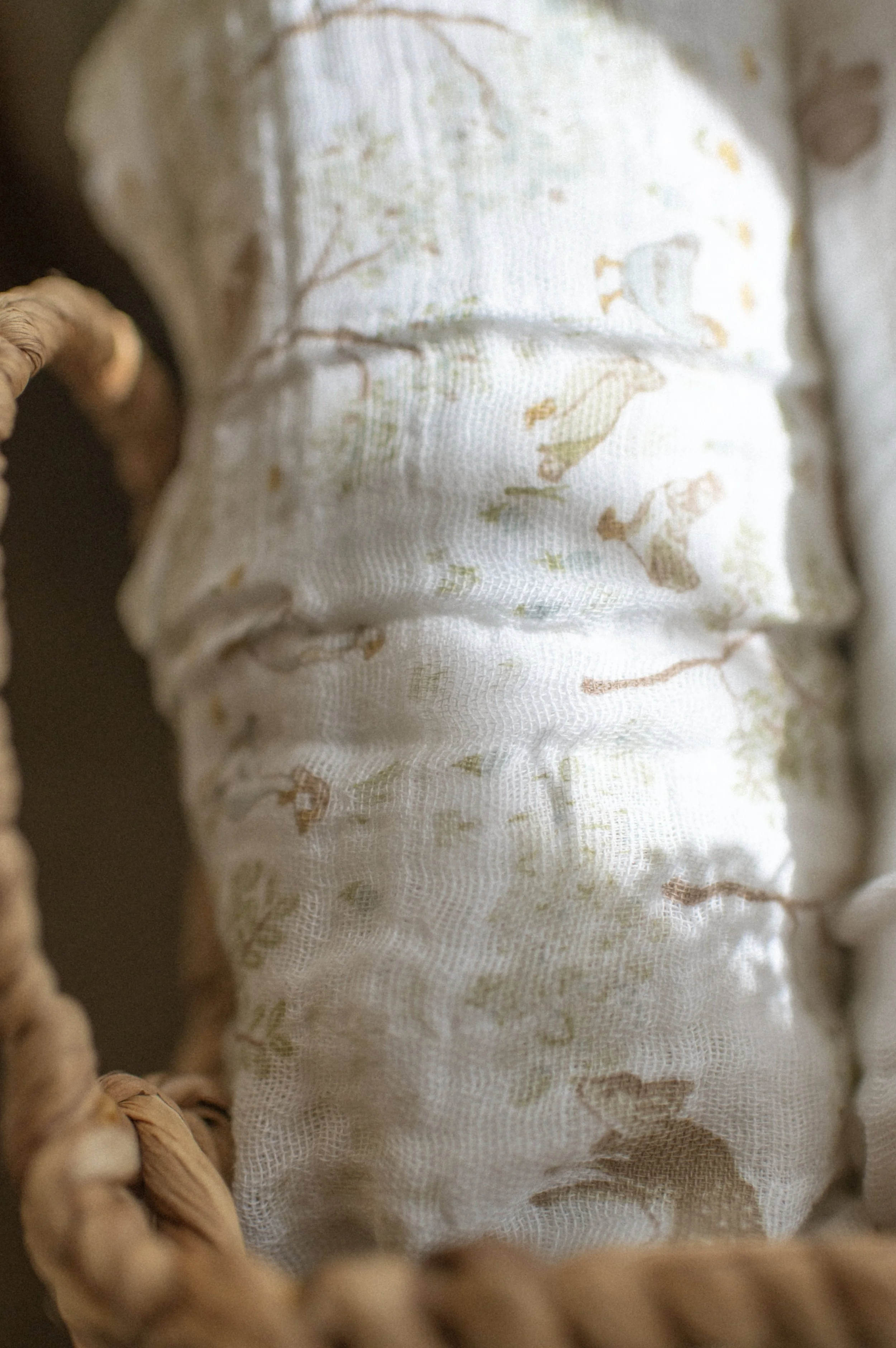 woodland deer organic cotton swaddle product photo in wicker basket