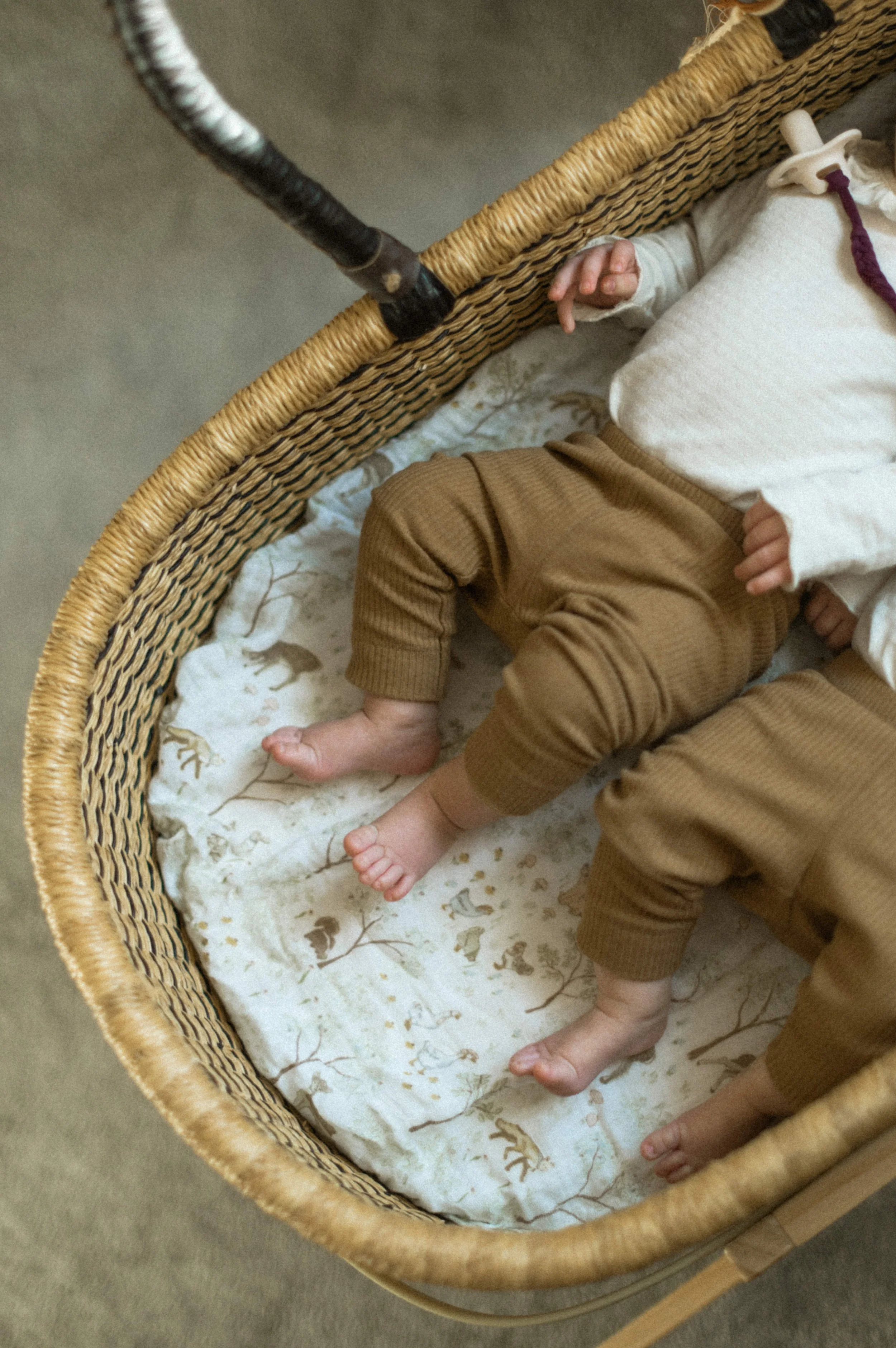 newborn twins in moses basket with organic cotton crib sheet