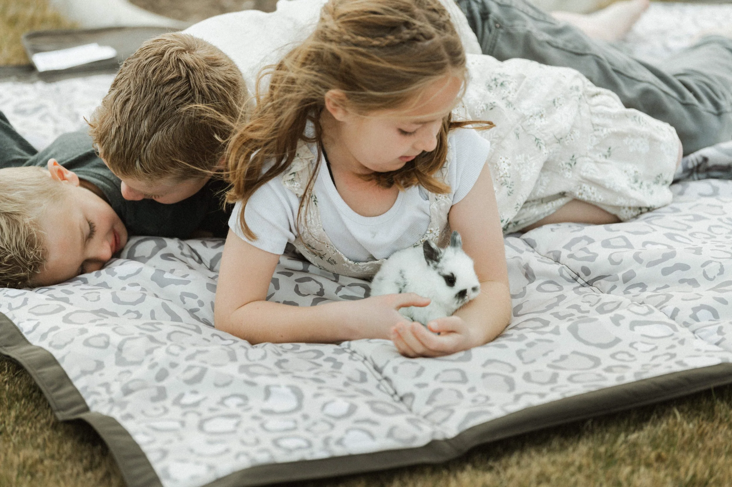 Curated picnic blanket product photography set with kids and bunny neutral greys