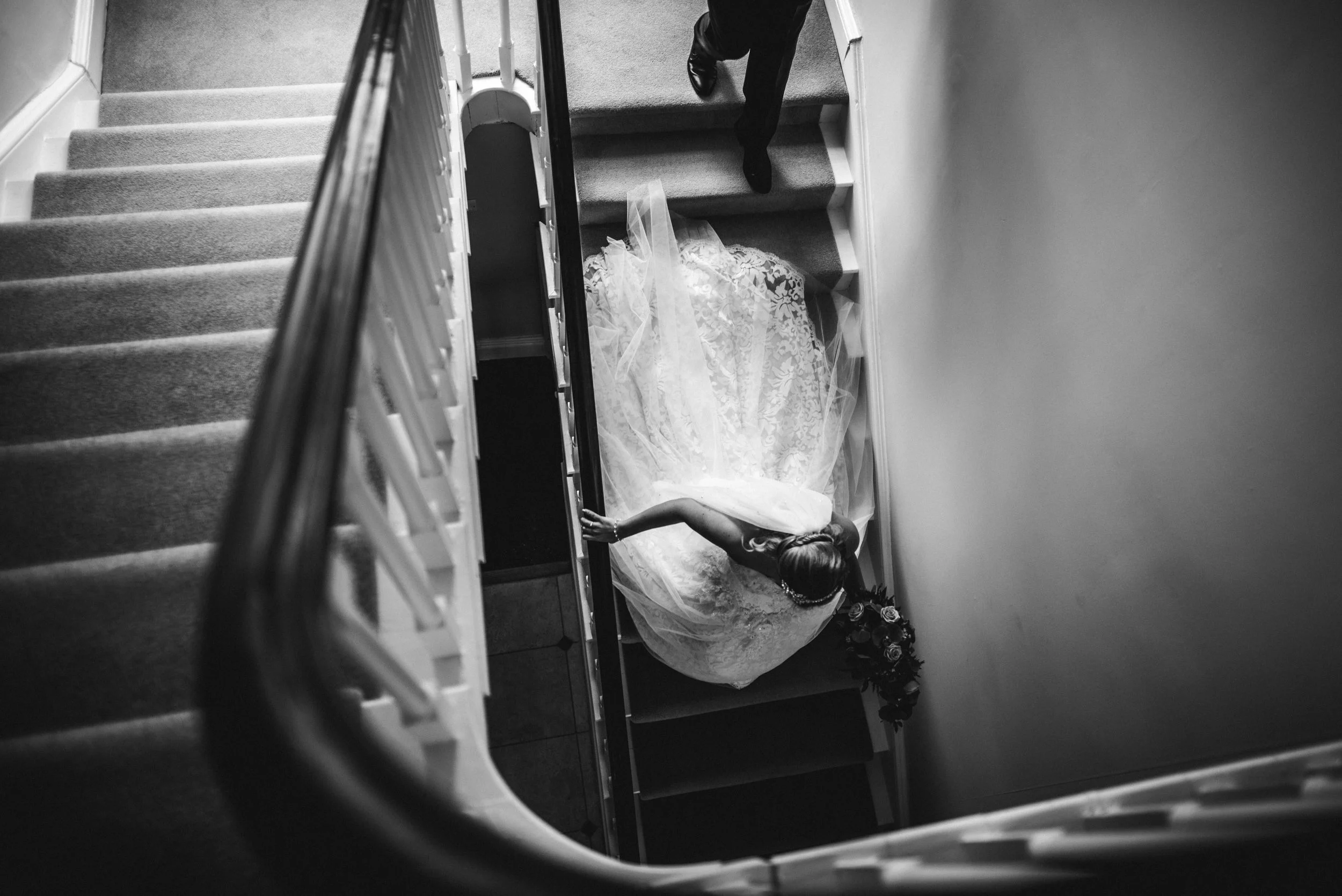 Nikon D750, Nikon 24mm 1.4 @ f1.6 ISO 640 1/250th. There was a large window behind them which threw a lot of light onto the bride and her dad. Then a simple black & white conversion in Lightroom, bringing down the blacks and increasing the contrast slightly then a tiny crop to crop out dads hands.