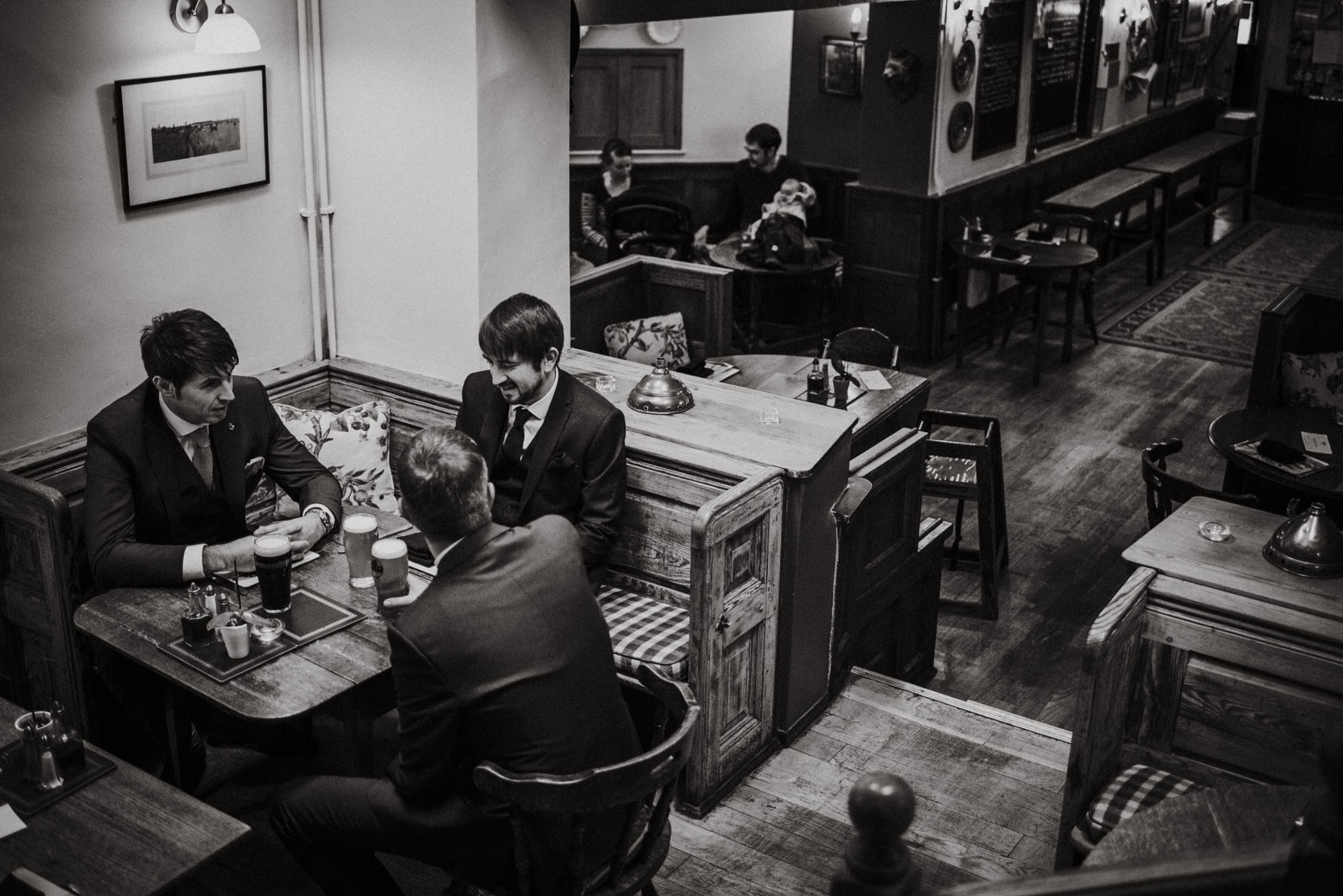 Candid unposed documentary wedding photographer Louise Jacob - Groom and groomsmen having a pint in The Red Lion and Manor in Burnsall