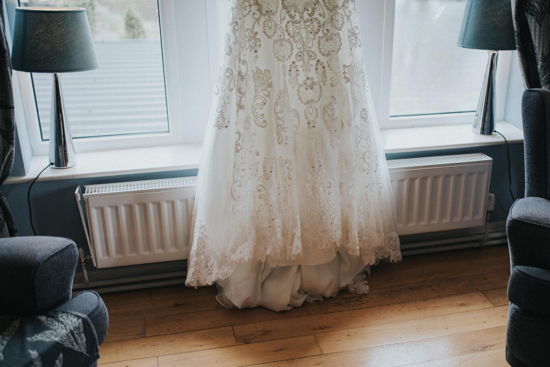 Candid unposed documentary image of a wedding dress hanging in the window
