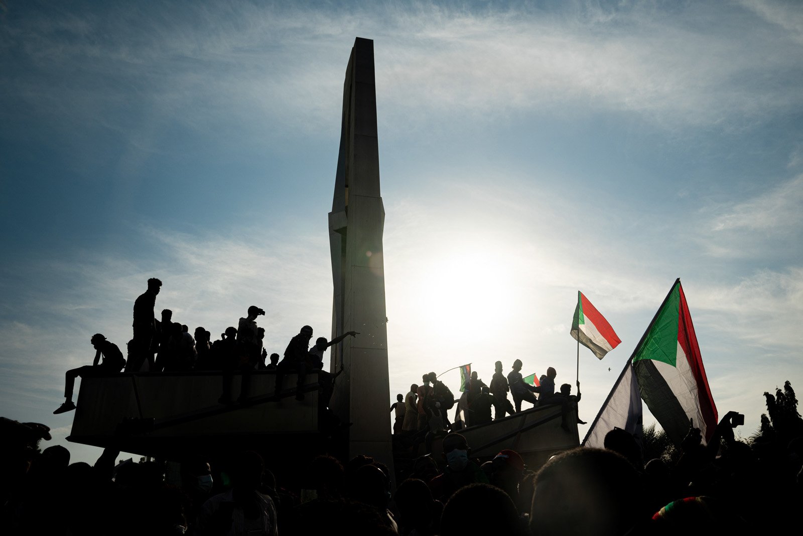  Des manifestants soudanais sur un monument ornant l’entrée du palais présidentiel où réside le leader du coup d'état, le général Abdel Fatah Al Burhan. Khartoum, 19 décembre 2021. 