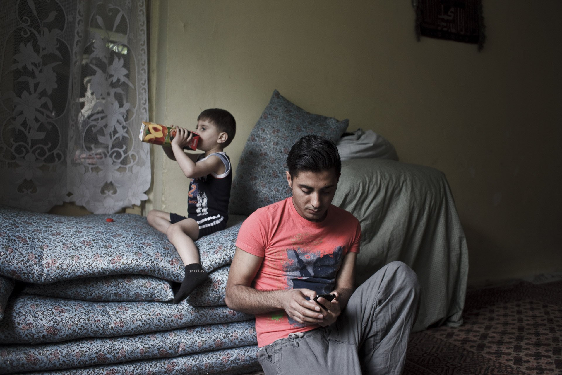  Dans sa chambre, qu’il partage avec son neveu, Abdullah discute avec sa “petite amie”. Il alterne entre Viber, WhatsApp et Facebook pour tchater. Il ne l'a jamais rencontrée, elle habite en Afrique du Sud. Kaboul, Afghanistan, 2013 . 