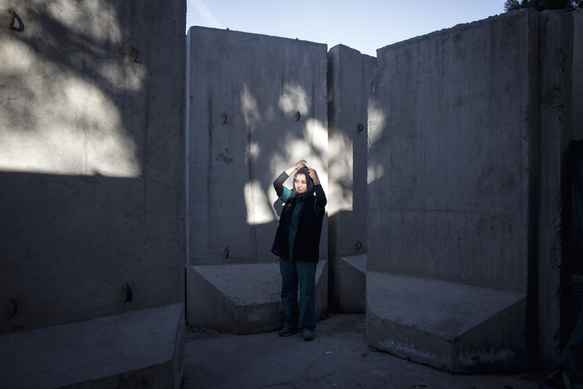  Mariam, apprentie vétérinaire, devant son lieu de travail, une clinique pour animaux de compagnie, dont la clientèle est principalement étrangère. La sécurité de l’entrée est renforcée par des murs de béton, comme beaucoup d’endroits fréquentés par 