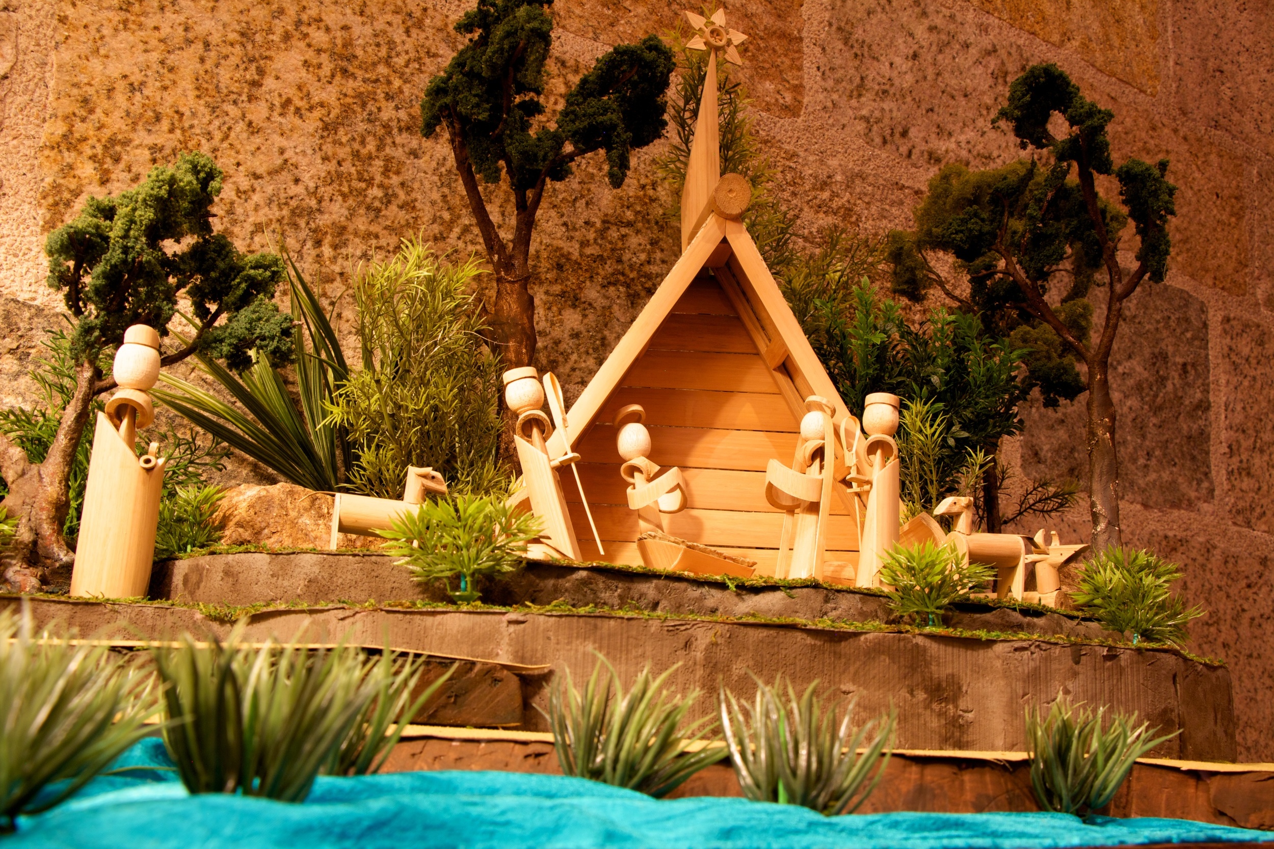 Figure 5: This Nativity was collected in the village of Genting, Central Java, Indonesia. It was made by Markus and his wife Niniek, who pastor a Christian congregation in the village. They have five children, including one set of twins, and make Nativities to help support the family. Bamboo Nativities of this type have been made in the region since at least the 1960s. This Nativity includes a stable, Star of Bethlehem, the Holy Family, two shepherds with sheep, an ox, a camel, and three wise men. Mary, Joseph and the Christ Child all have haloes. The round hollow form of bamboo canes has been creatively adapted by the artist to make the various figures.