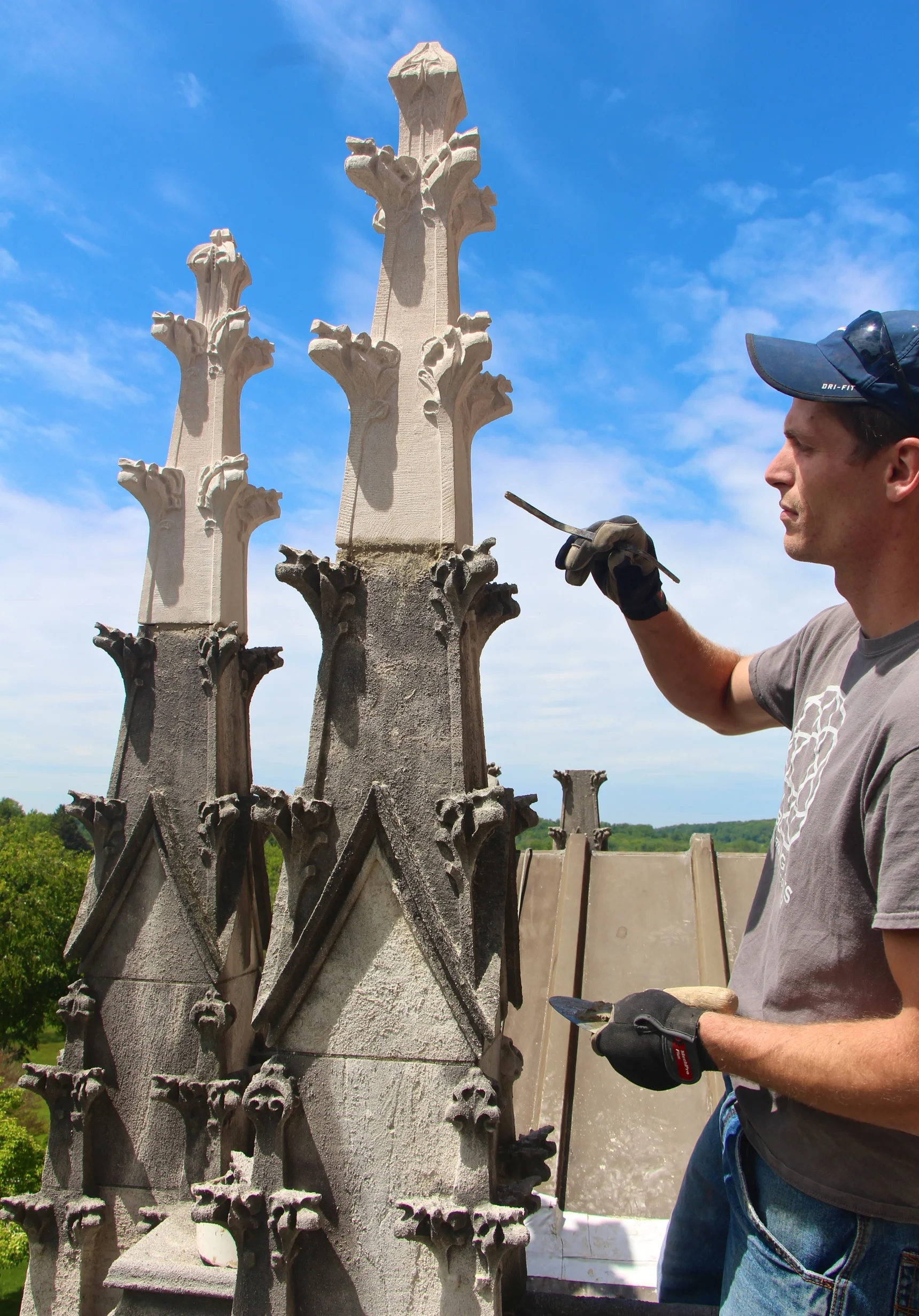 Figure 8: Grayson Zuber applies restoration mortar to secure one of the new limestone finials.