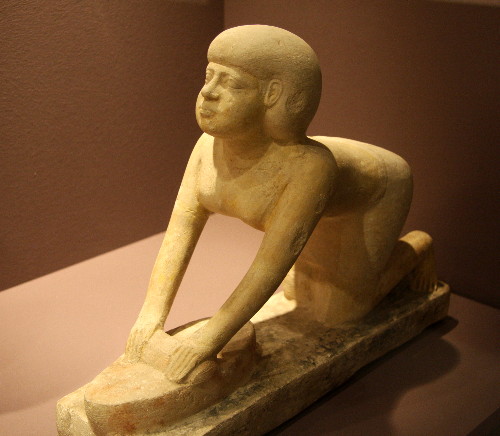 A "servant statue" of a woman grinding grain from the tomb of Tep-em-ankh, in the permanent collection of the Roemer- und Pelizaeus- Museum in Hildesheim, Germany.