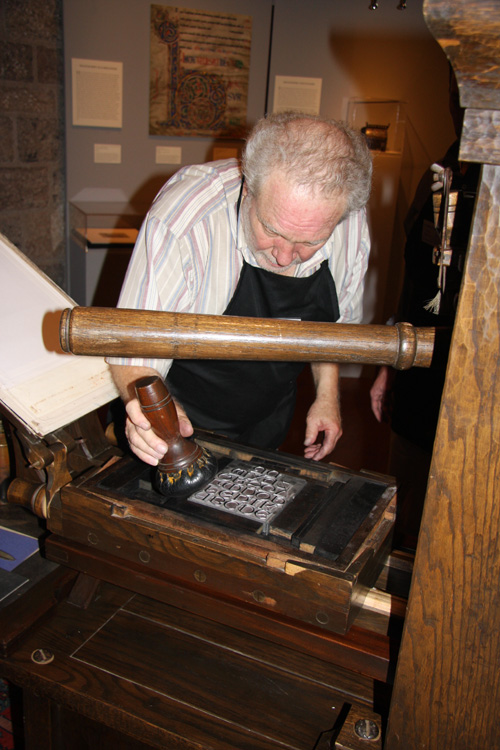Allen Bjorkman inks the printing plate with a leather ink ball during a demonstration.