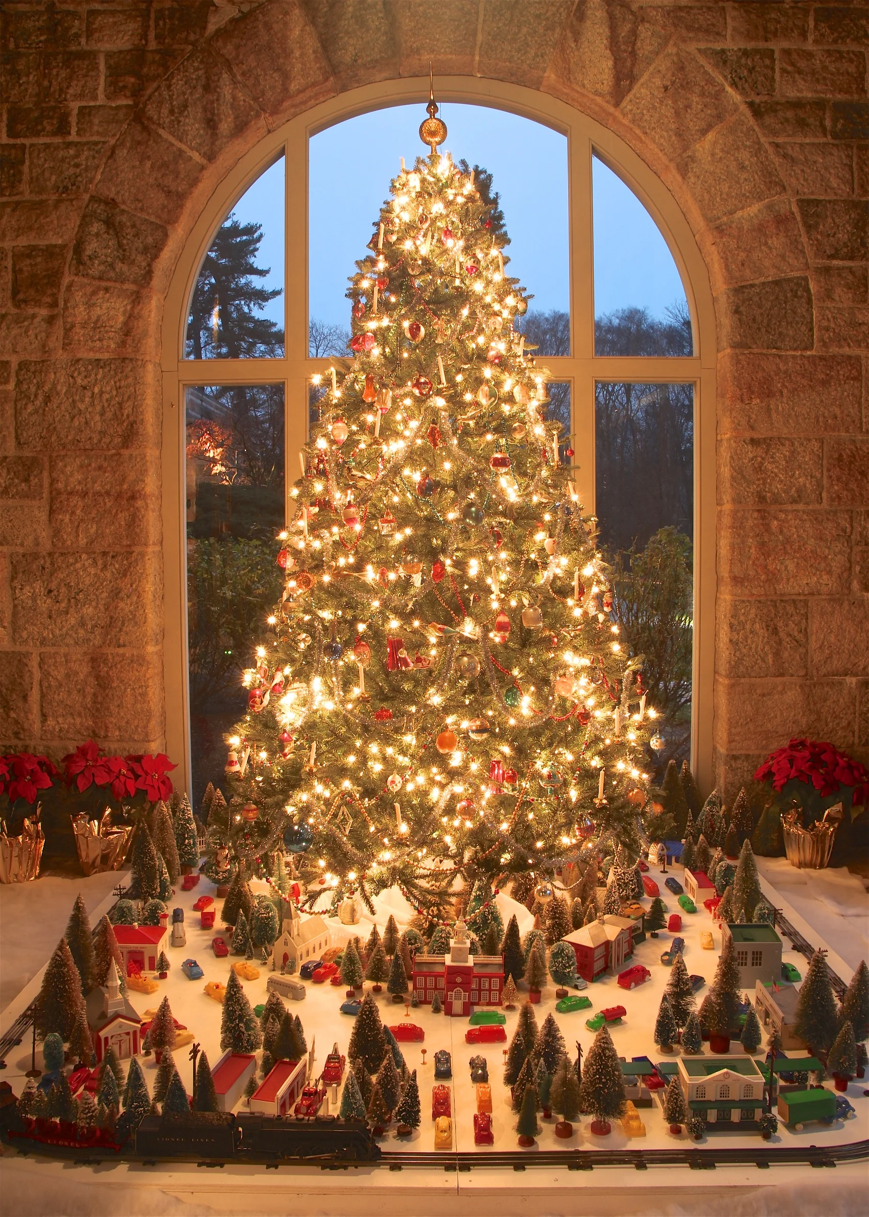 Figure 16: Christmas villages beneath the tree were popular throughout the 20th century. In 1947 Bachman Bros. in Philadelphia began manufacturing Plasticville, USA, a line of injection-molded plastic buildings and accessories for toy trains and Christmas villages. Many Americans saw plastic as a symbol of post-World War Two progress. Plasticville, with its child-friendly, glueless, snap-together construction, quickly became the most popular brand of train buildings. Plasticville city on loan from the National Christmas Center and Museum, Lancaster, PA.
