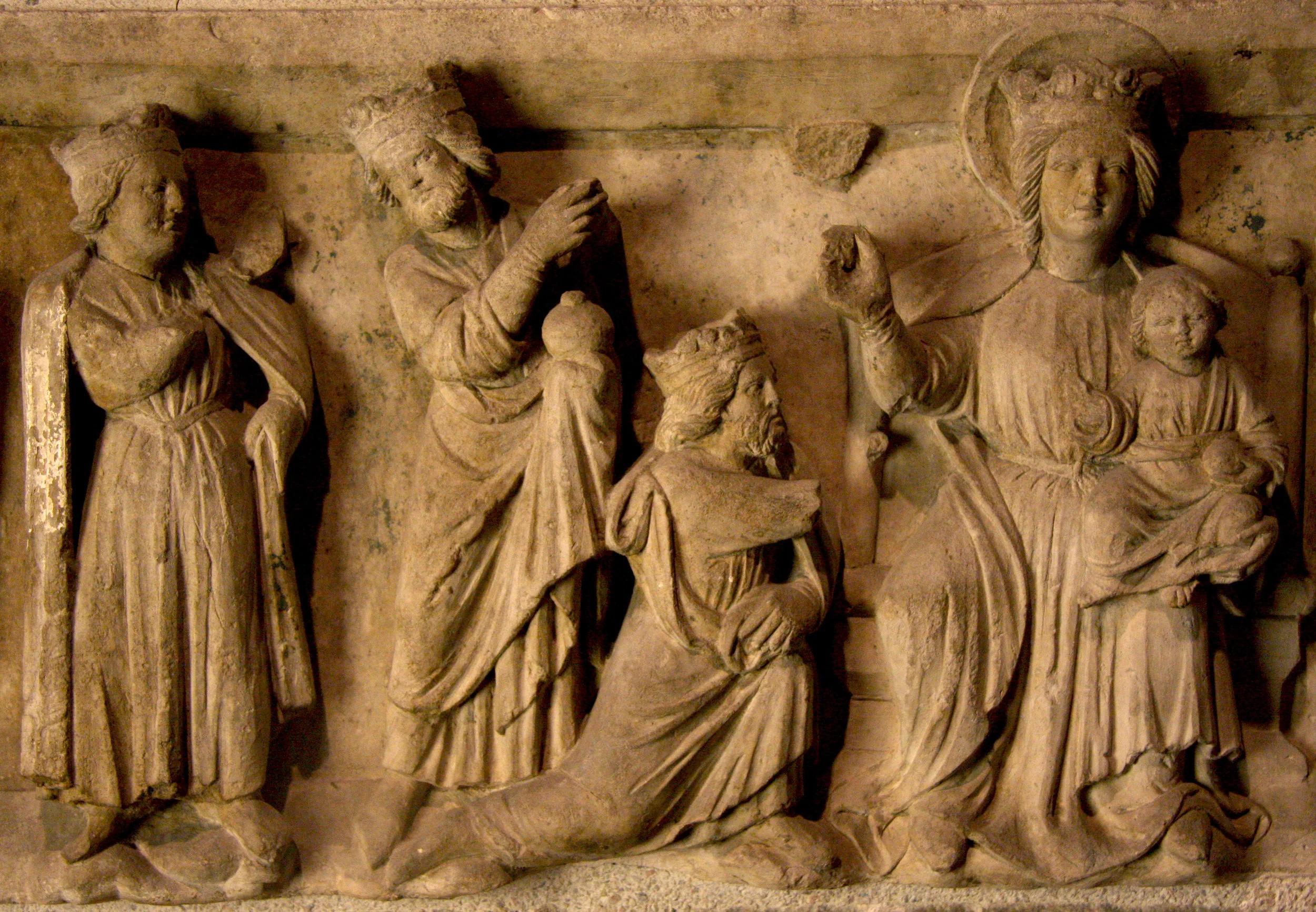 Figure 5: This limestone relief with the Adoration of the Magi, in the collection of Glencairn Museum (09.SP.119), was made in 13th-century France. All three of the Magi are represented as kings with crowns, in keeping with medieval tradition. The first king, whose arm is broken off, is depicted kneeling and presenting a gift. Collection of Glencairn Museum.