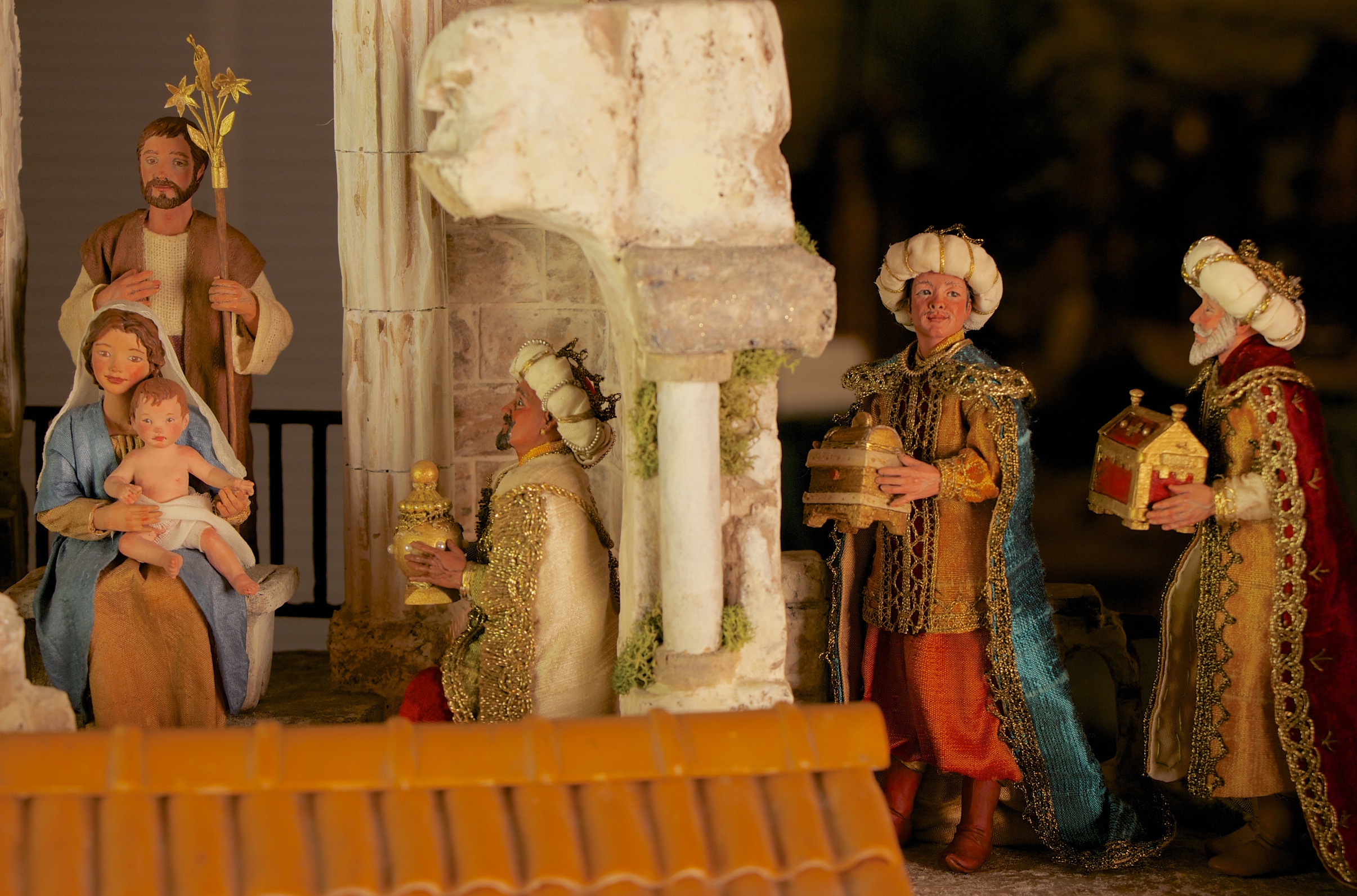 Figure 8: This Nativity scene, inspired by the tradition of the Presepio in Naples, Italy, was made by the American artists Karen Loccisano and R. Michael Palan. A Presepio presents the birth of Jesus Christ in the context of an 18th-century Italian village. The Holy Family is presented within a Roman ruin, which represents the end of the pagan world, from the remnants of which Christianity was born. The Magi in this Nativity represent three different ages (young, middle aged, and elderly) as well as three different continents (Africa, Asia, and Europe). On loan from Karen Loccisano and R. Michael Palan.