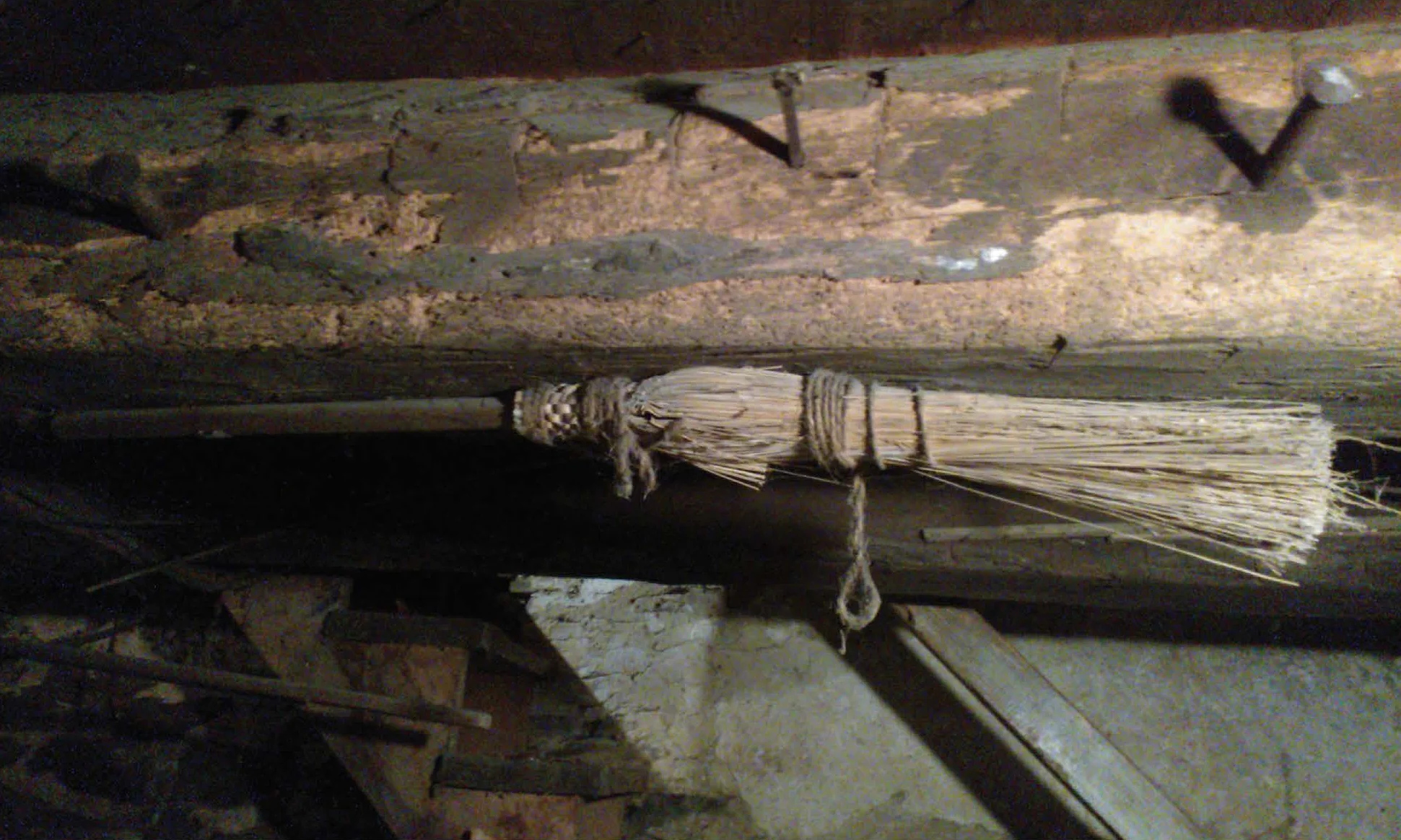Figure 30: A concealed broom in a Berks County farm house, nailed to a floor joist visible by the basement stairs. Private Collection, photo courtesy of Patrick J. Donmoyer.